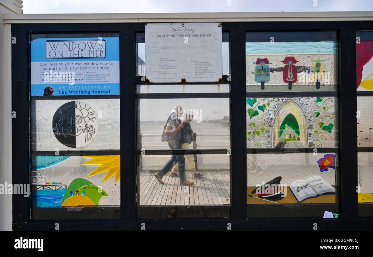 Worthing UK 17 septembre 2021 - les visiteurs marchent à côté des fenêtres d'art colorées sur Worthing Pier dans un après-midi chaud le long de la côte sud : crédit Simon Dack / Alamy Live News Banque D'Images