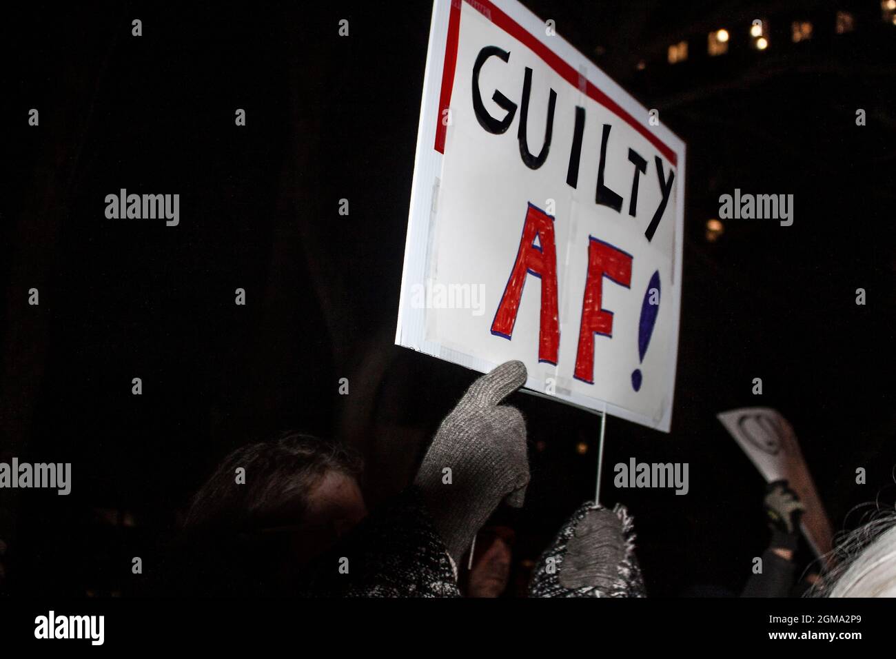 Signez AF coupable lors d'un rassemblement de nuit avant la mise en accusation avec le doigt ganté pointant vers le message Banque D'Images
