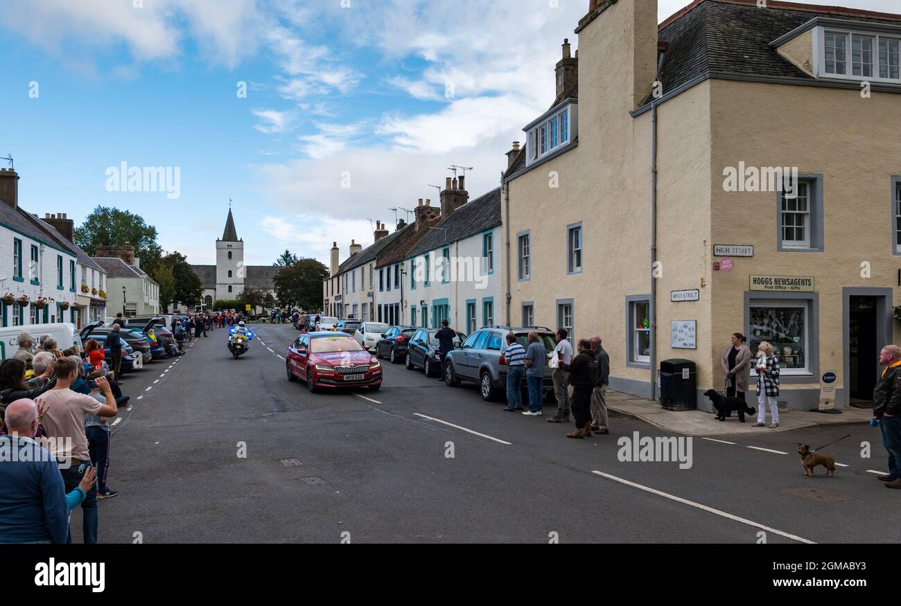 Une voiture de police et une voiture de soutien J Bell Tour of Britain passent dans le village de Gifford, East Lothian, Écosse, Royaume-Uni Banque D'Images