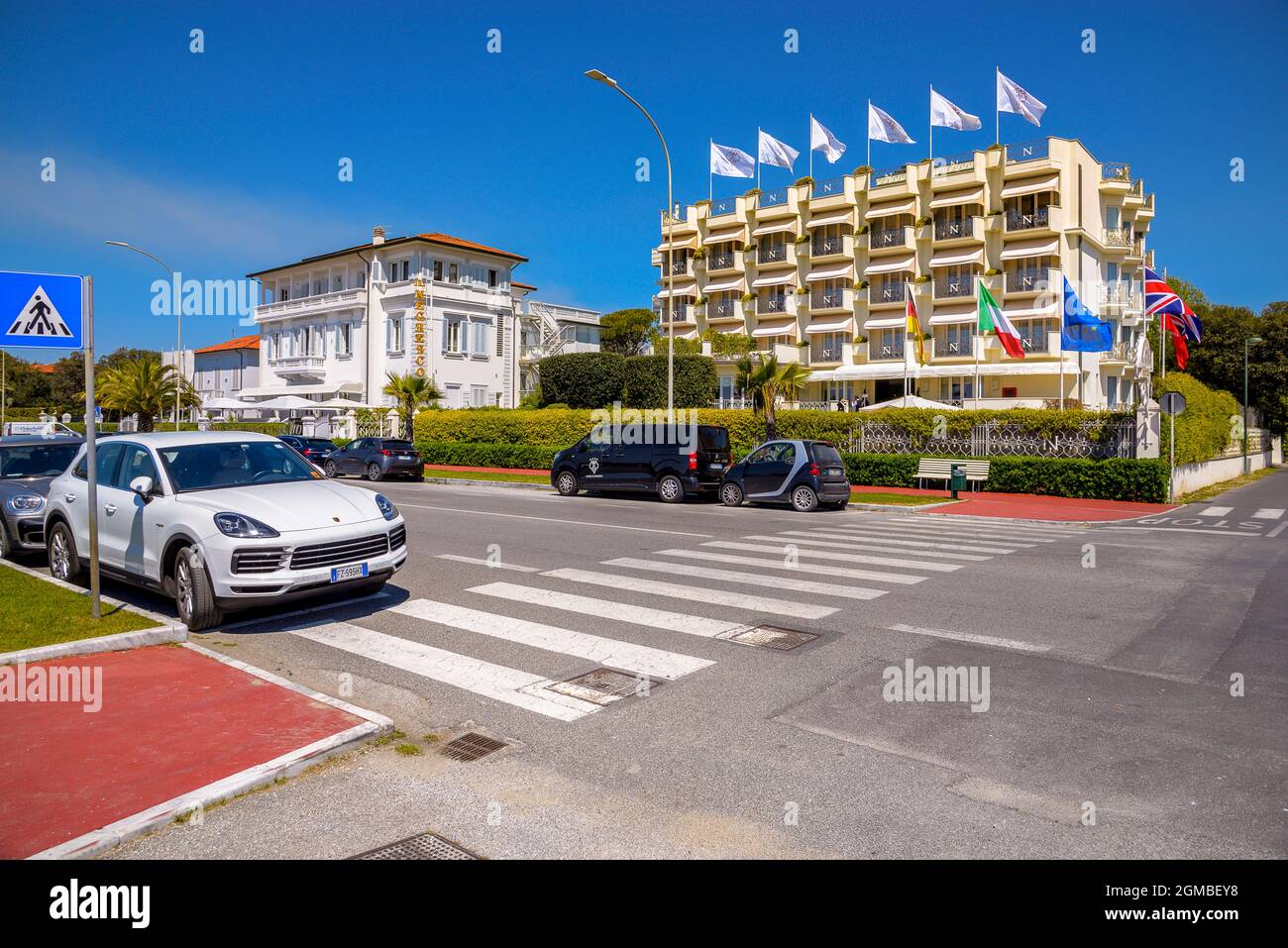 Quelques voitures de luxe passent le long de la route côtière en face des hôtels 4 et 5 étoiles et des résidences de luxe forte dei Marmi, riviera, Lucca Toscane, Italie Banque D'Images