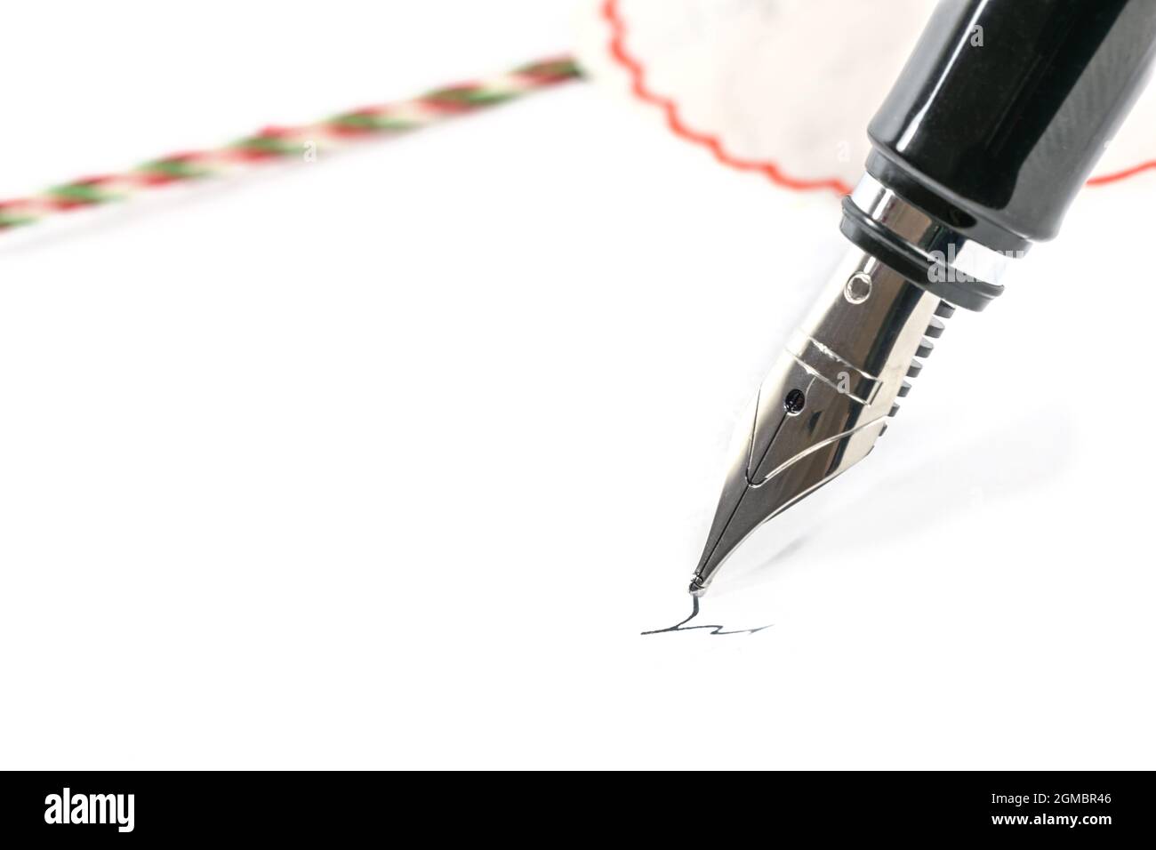 Stylo plume signant un contrat à côté d'un sceau, fond blanc, espace de copie, gros plan avec mise au point sélectionnée et profondeur de champ étroite Banque D'Images