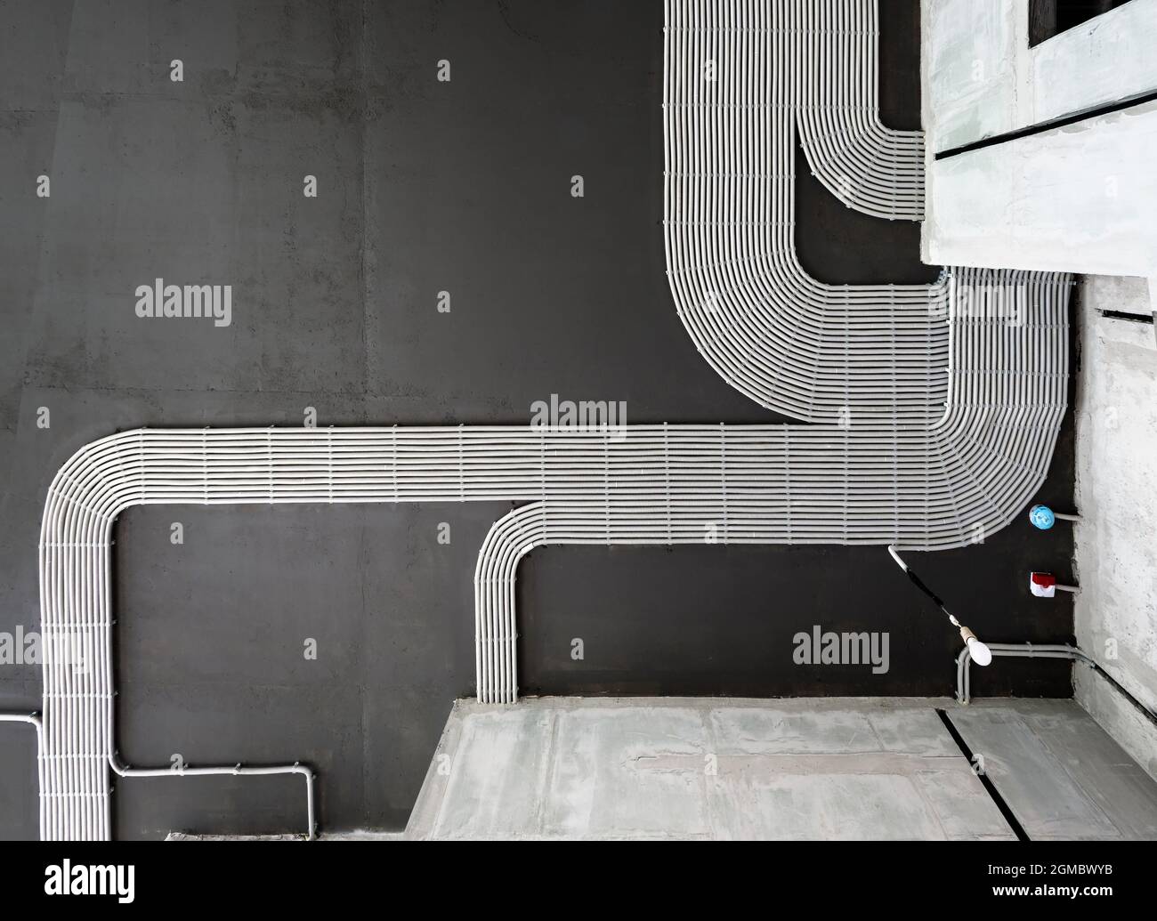 Câbles et tuyaux électriques sur fond de plafond en béton de la maison, tuyaux en plastique avec fils dans la pièce vide. Lignes de tubes de câblage en pvc après professionnel Banque D'Images