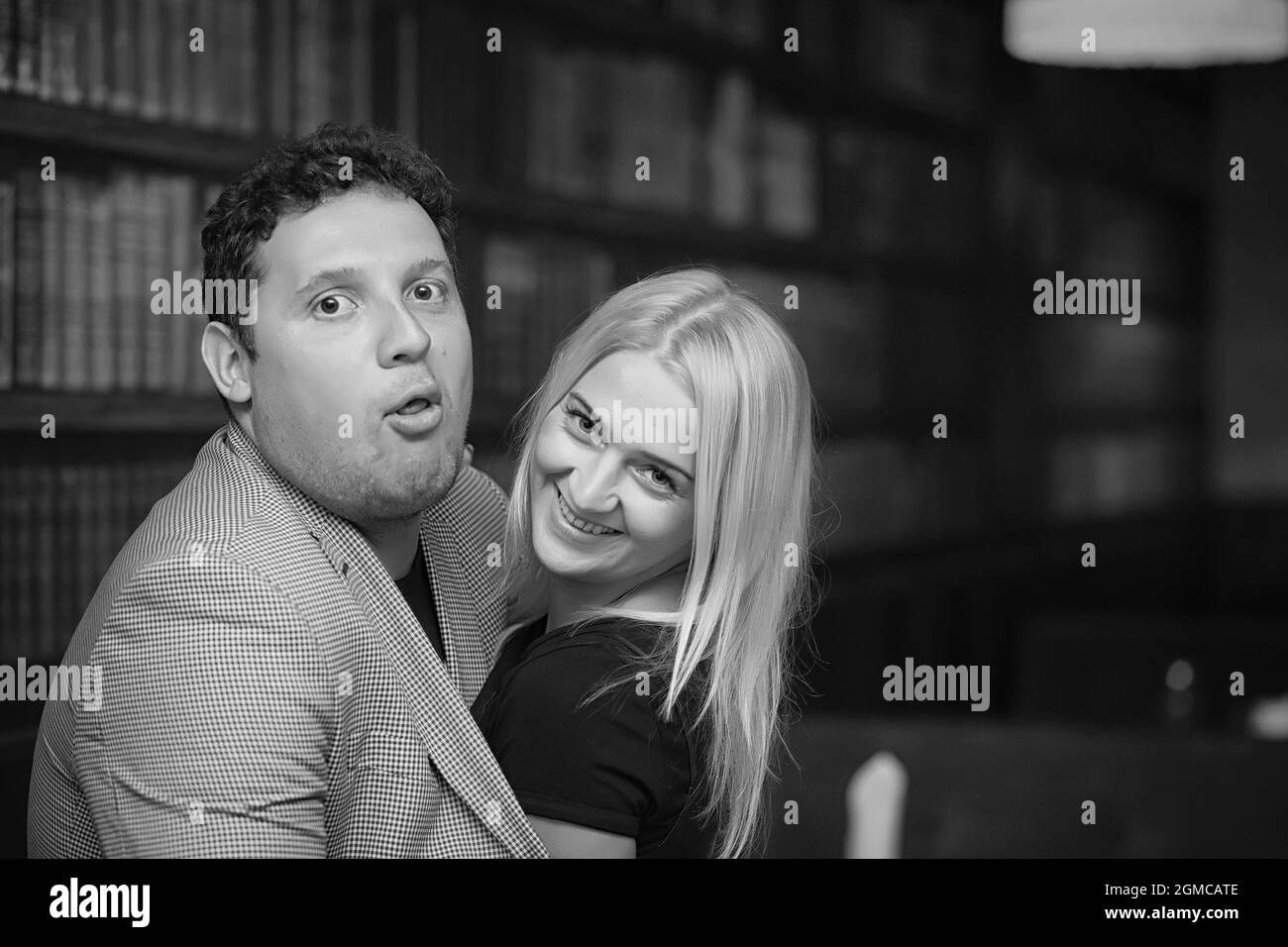 Jeune couple, une fille avec un jeune homme qui s'embrasse et pose sur l'appareil photo. Jeune famille. Le mari dans la veste encadre sa femme. Banque D'Images