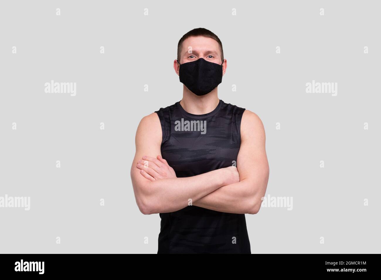 Sportif portant un masque médical.Homme mains croisées avec masque.Vie saine, protection médicale, concept sportif Banque D'Images