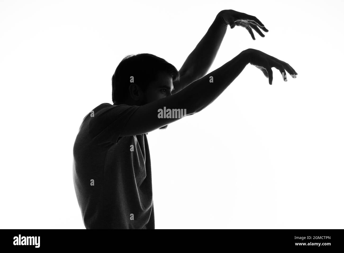 homme barbu dans l'ombre plaque anonyme en étain avec ses mains lumière arrière-plan Banque D'Images