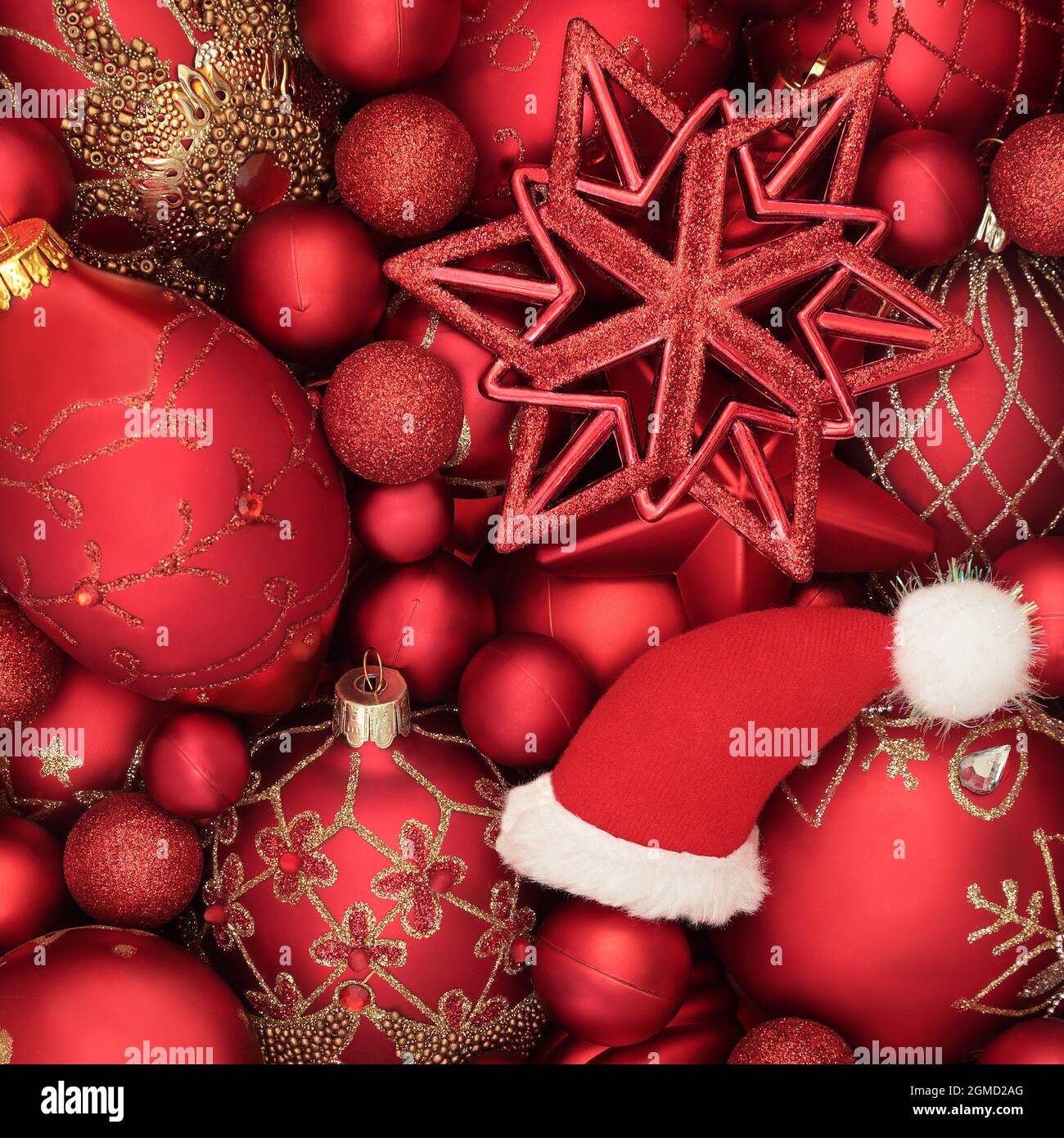 Chapeau de père Noël et boules rouges décorations de Noël fond de fête. Composition abstraite pour Noël festive. Vue de dessus. Banque D'Images