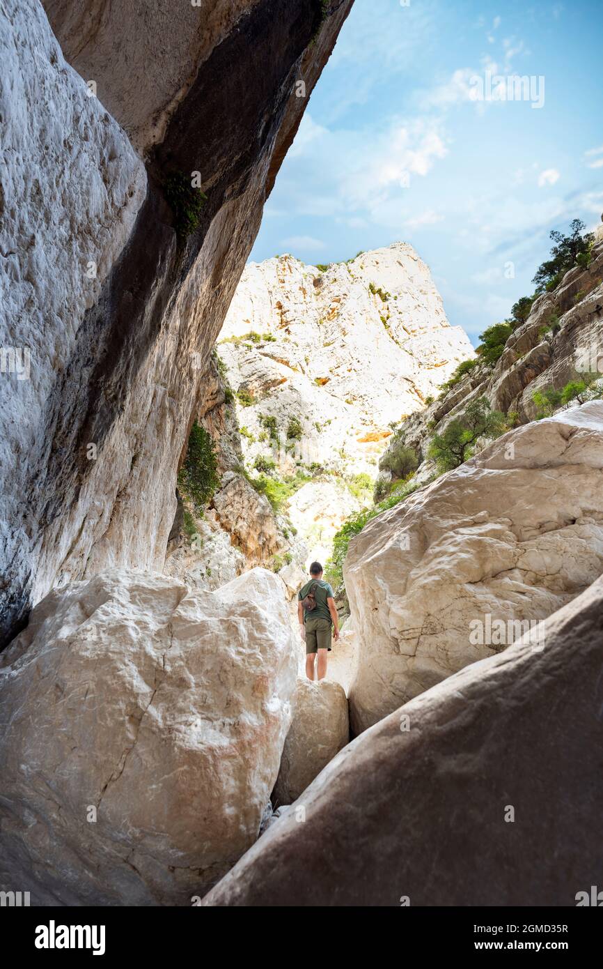Vue imprenable sur une personne qui fait de la randonnée dans la gorge de Gorropu pendant une journée ensoleillée. Banque D'Images