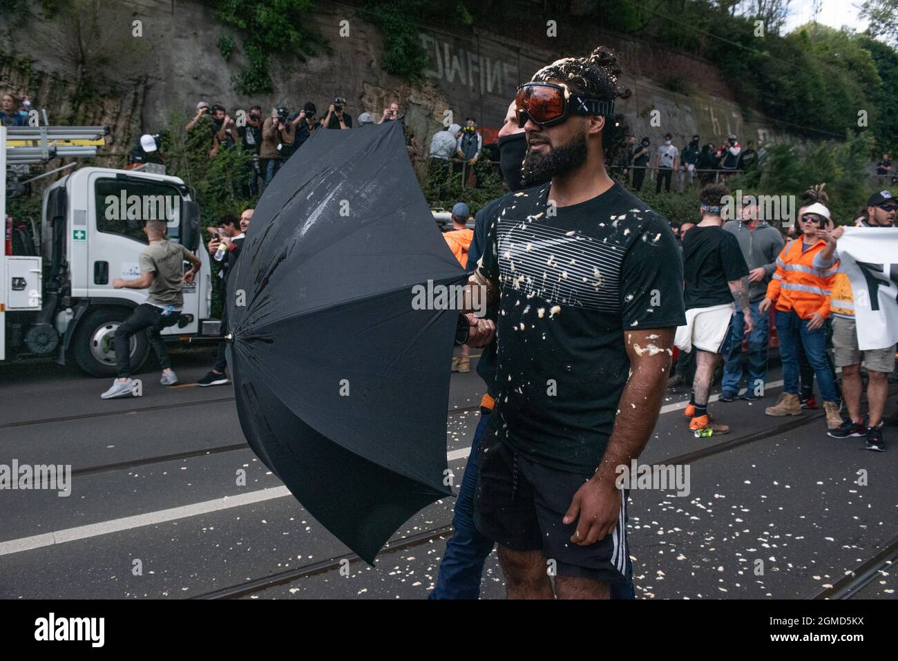 Melbourne, Australie. 18 septembre 2021. Un manifestant anti-verrouillage utilisant un parapluie et des lunettes de protection après avoir été aspergé de poivre par la police. Credit: Jay Kogler/Alay Live News Banque D'Images