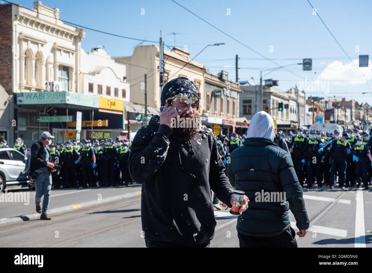 Melbourne, Australie. 18 septembre 2021. « Je viens d'avoir du poivre ! » Un manifestant anti-verrouillage tenant une CAN d'alcool, au téléphone à quelqu'un après avoir été aspergé de poivre par la police. Credit: Jay Kogler/Alay Live News Banque D'Images