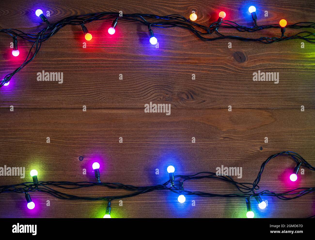 Arrière-plan de Noël avec guirlande lumineuse sur une surface en bois, lumière de guirlande de Noël, espace pour le texte, vue de dessus Banque D'Images