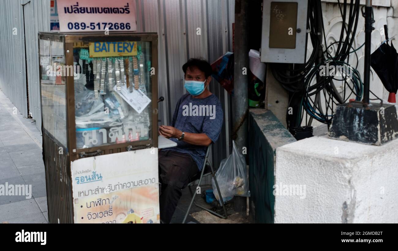 Homme vendant des batteries de montre dans la rue près de la station BTS de Chit LOM Bangkok Thaïlande Banque D'Images