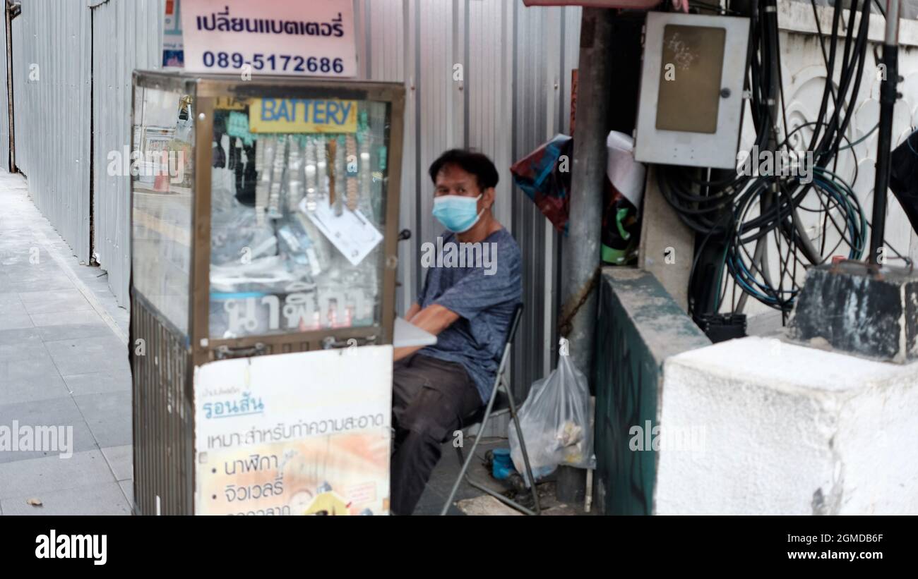 Homme vendant des batteries de montre dans la rue près de la station BTS de Chit LOM Bangkok Thaïlande Banque D'Images