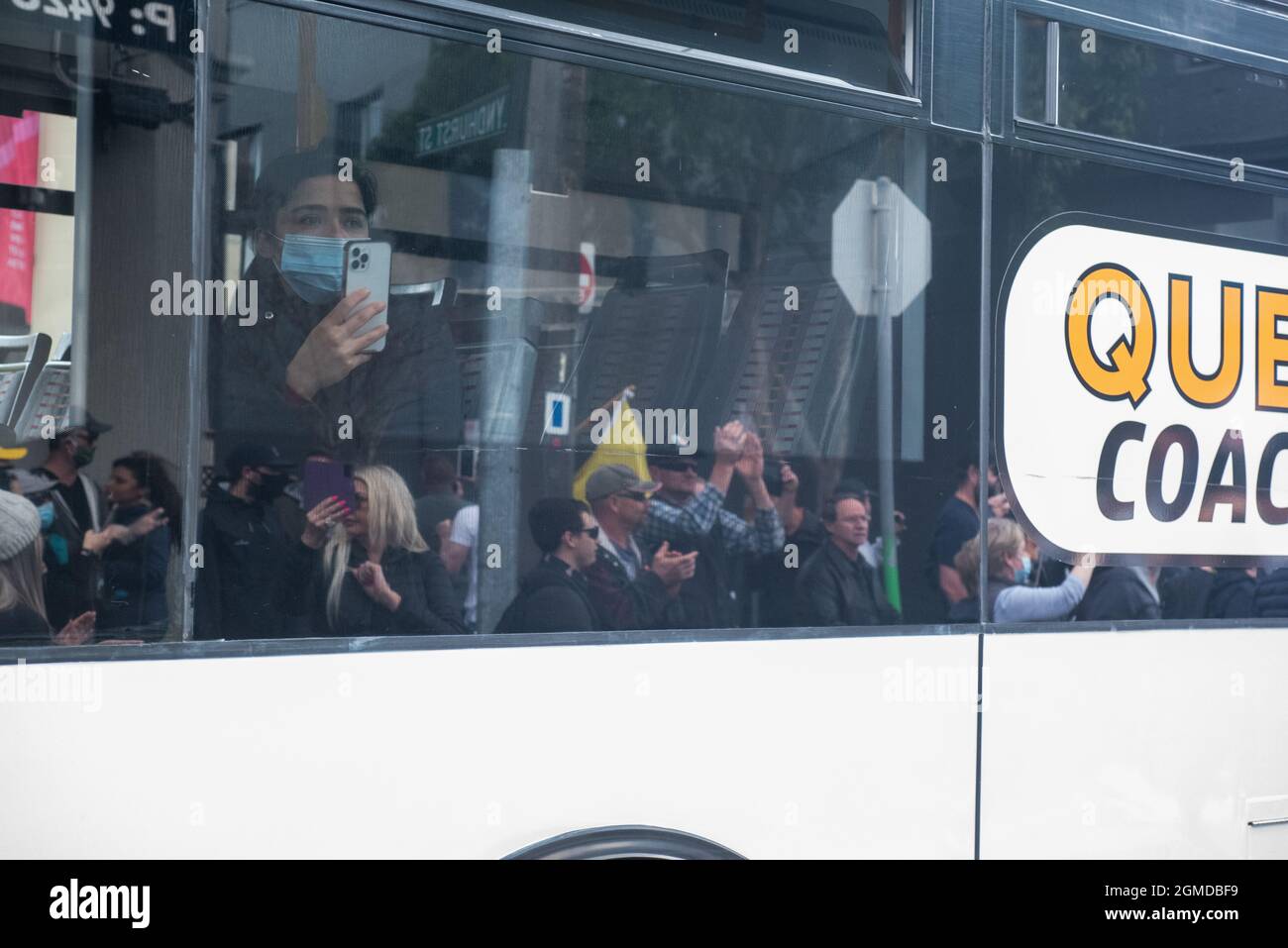 Melbourne, Australie. 18 septembre 2021. Un spectateur qui monte dans un bus filme la manifestation anti-verrouillage sur son téléphone. Credit: Jay Kogler/Alay Live News Banque D'Images