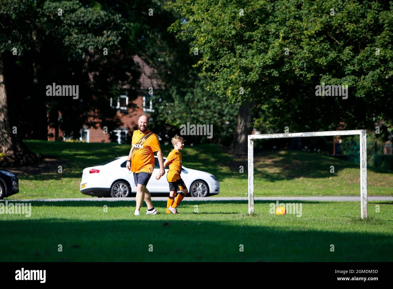 Un père et un fils jouent au football dans le parc avant le match Banque D'Images