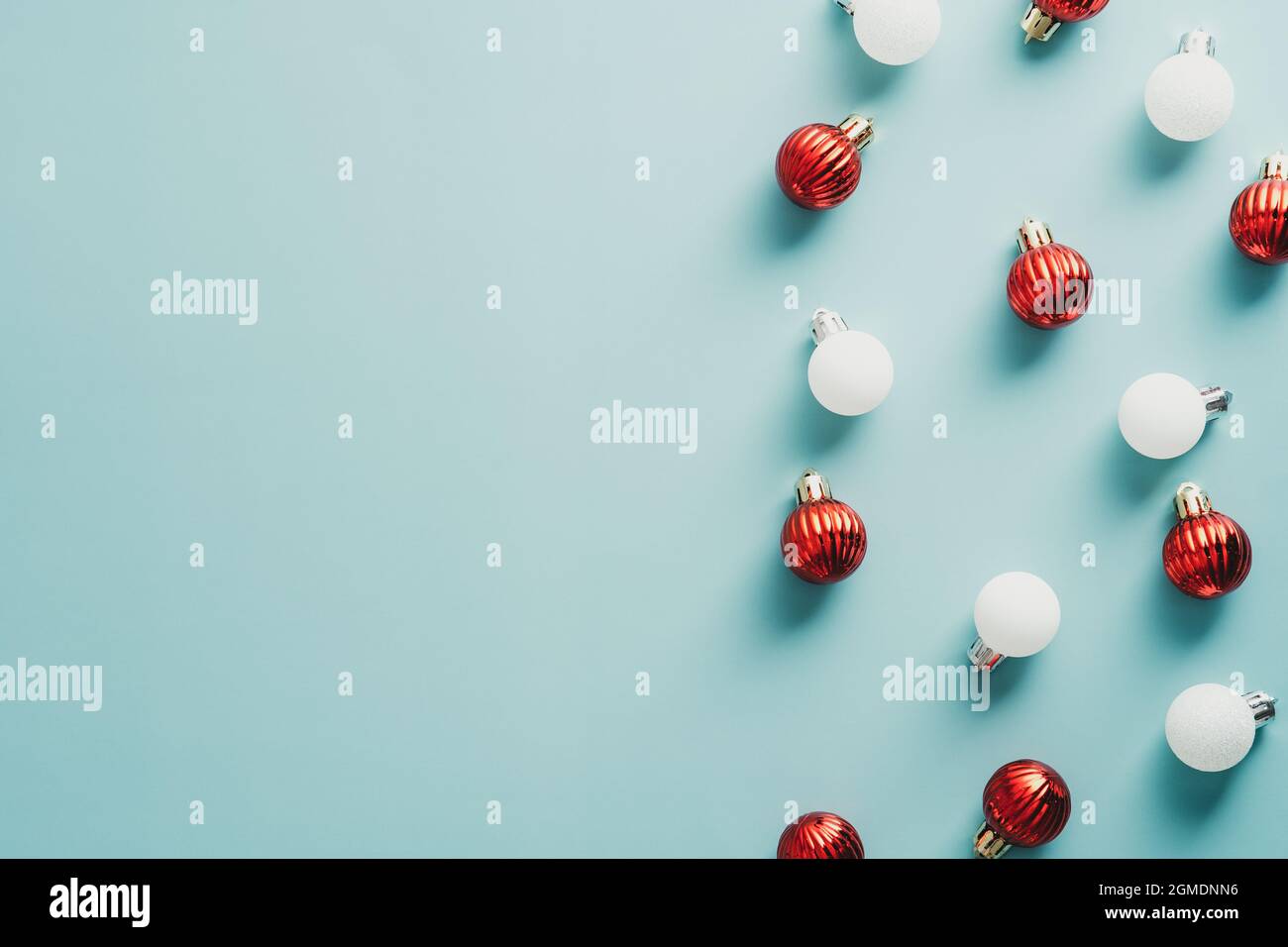 Boules de Noël rouges et blanches sur fond bleu. Vue de dessus avec espace de copie, plan de travail. Maquette de carte de vœux du nouvel an, modèle de carte postale de Noël. Banque D'Images Boules de Noël rouges et blanches sur fond bleu. Vue de dessus avec espace de copie, plan de travail. Maquette de carte de vœux du nouvel an, modèle de carte postale de Noël. Banque D'Images
