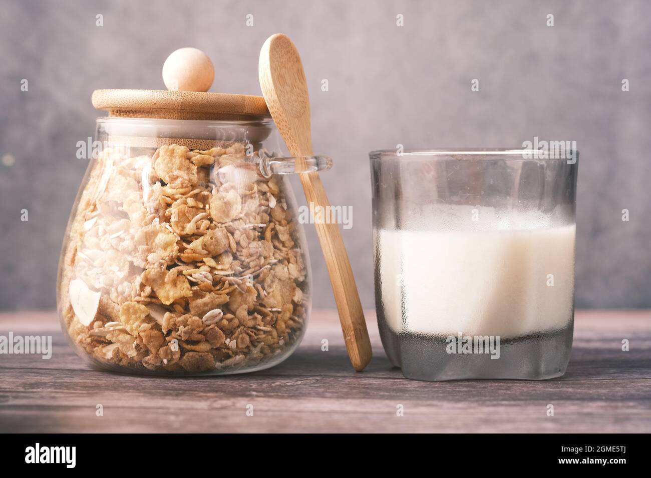muesli aux fruits séchés dans un pot avec un verre de lait sur la table, Banque D'Images