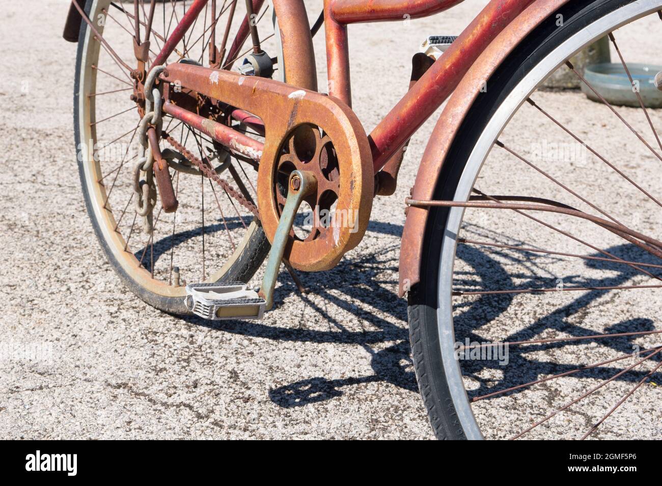 Détail de vieux vélo rouillé avec pédale et chaîne et son ombre sur le sol, à Zadar, Croatie Banque D'Images