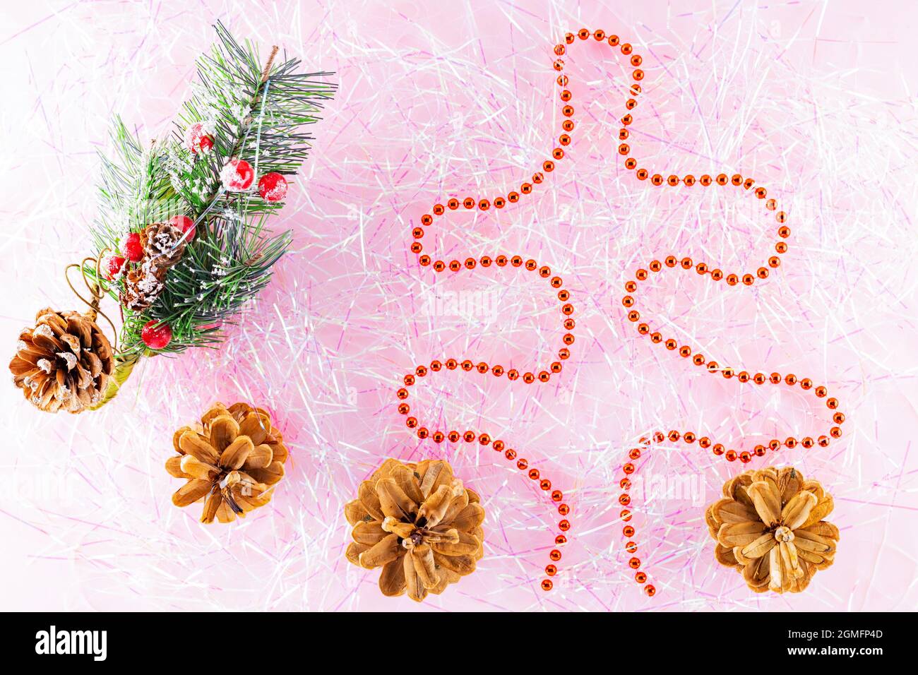 Sapin de noël à motif symbole de Noël et joyeux nouvel an avec perles rouges sur la guirlande. Perles de Noël sur guirlande rose. Concept de vacances. Vue de dessus Banque D'Images