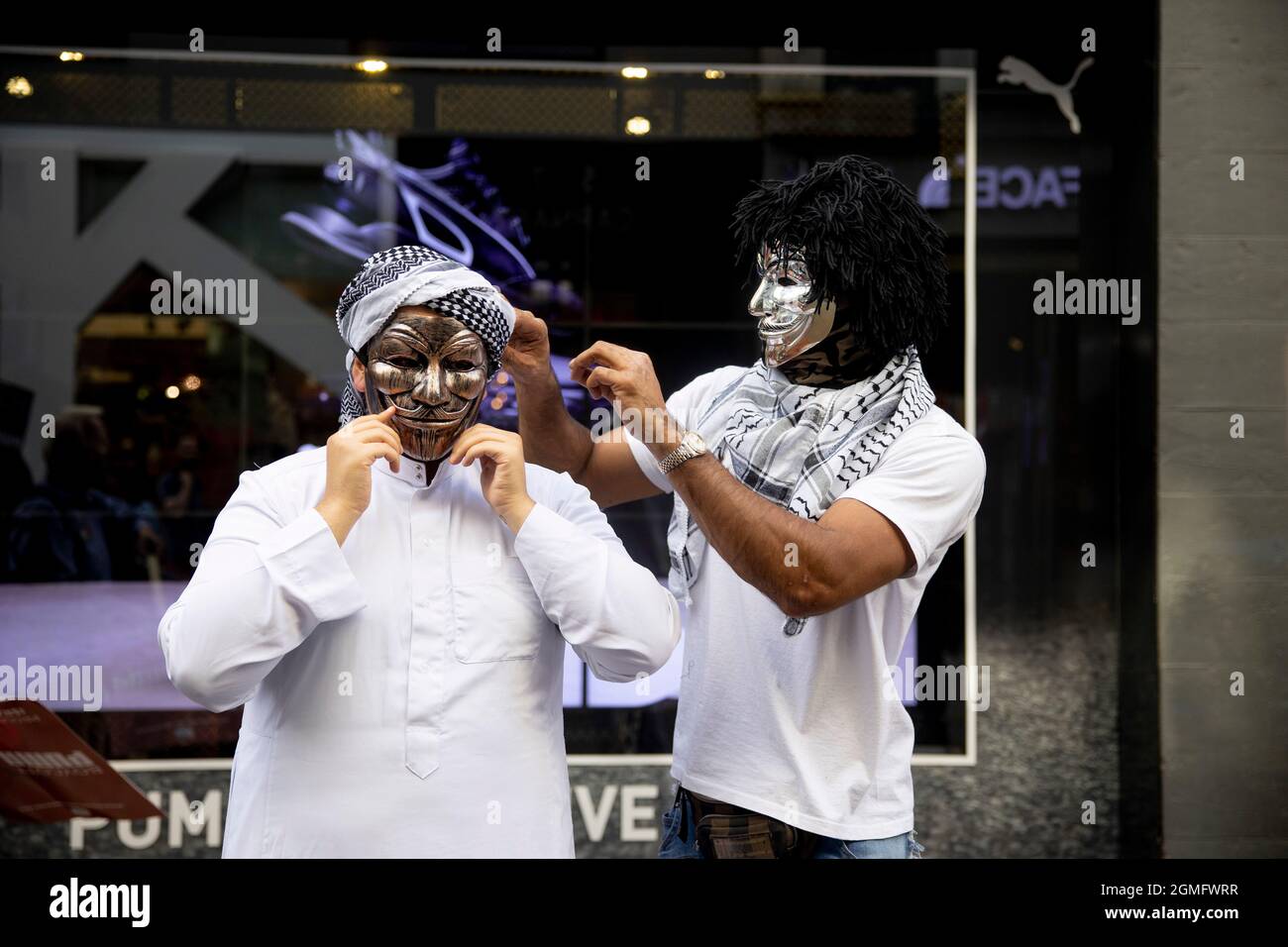 Londres, Royaume-Uni. 18 septembre 2021. Un manifestant qui aide l'autre à mettre un masque sur Carnaby Street pendant la manifestation.Une campagne de boycott mondial a été lancée par des partisans palestiniens contre Puma pour examiner leur parrainage de l'Association israélienne de football. Un petit groupe de contre-manifestants soutenant Israël s'est présenté lors de l'action de boycott à l'extérieur du magasin phare de Puma à Londres. Crédit : SOPA Images Limited/Alamy Live News Banque D'Images