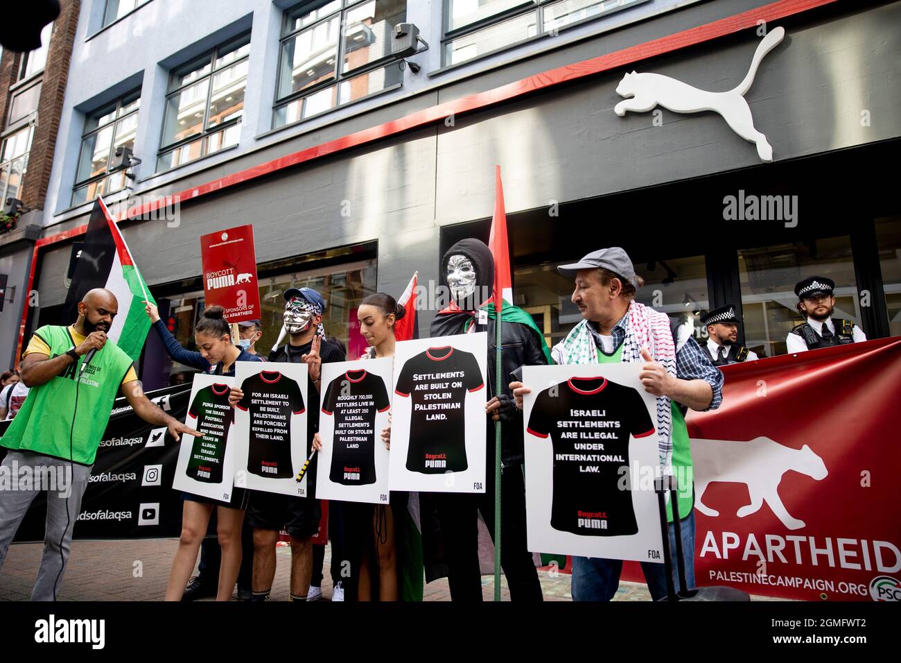 Londres, Royaume-Uni. 18 septembre 2021. Des Palestiniens tenant des pancartes exprimant leur opinion, devant le magasin phare de Puma à Carnaby Street pendant la manifestation.Une campagne de boycott mondial a été lancée par des Palestiniens contre Puma pour examiner leur parrainage de l'Association israélienne de football. Un petit groupe de contre-manifestants soutenant Israël s'est présenté lors de l'action de boycott à l'extérieur du magasin phare de Puma à Londres. Crédit : SOPA Images Limited/Alamy Live News Banque D'Images