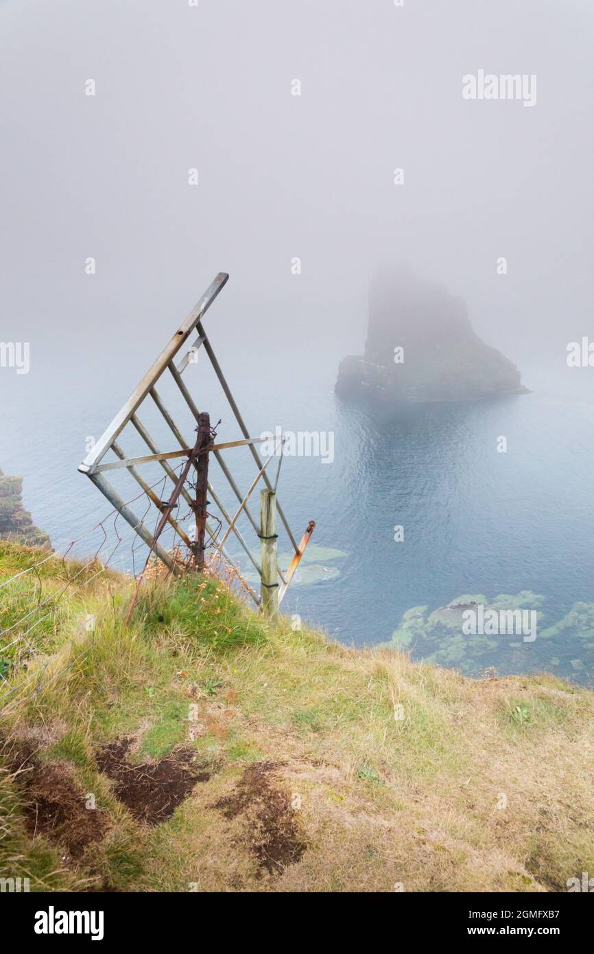 Vieille porte tombant du bord de la falaise à Duncansby Head et piles de mer, à proximité de John O Groats, Caithness, nord-est de l'Écosse avec un fret de mer. Banque D'Images