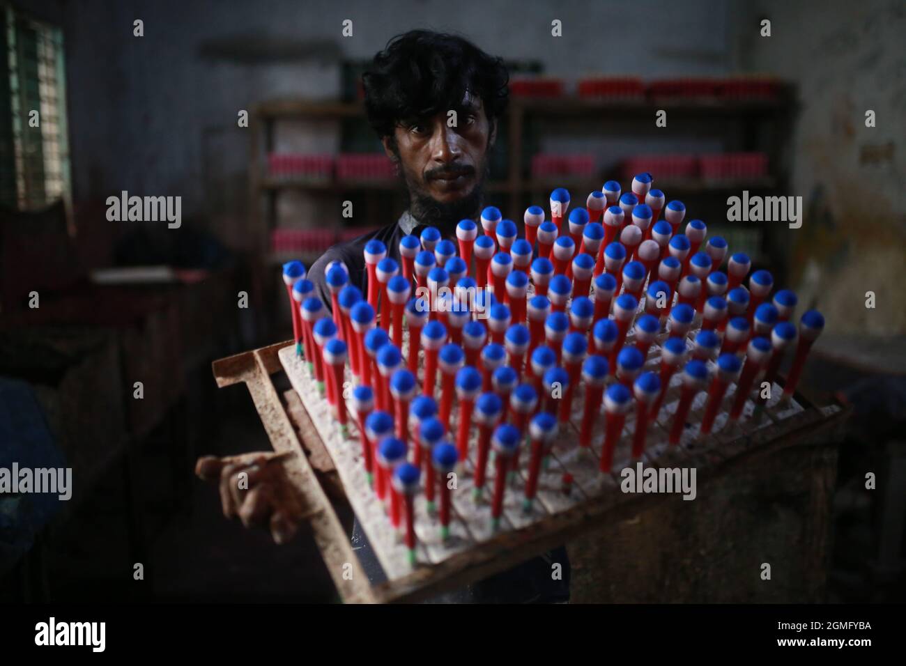 Un homme travaille dans une usine de ballons à Dhaka, au Bangladesh. Les usines de ballons sont en train de mourir en raison de la prise de produits en chines sur le marché bangladais. Banque D'Images