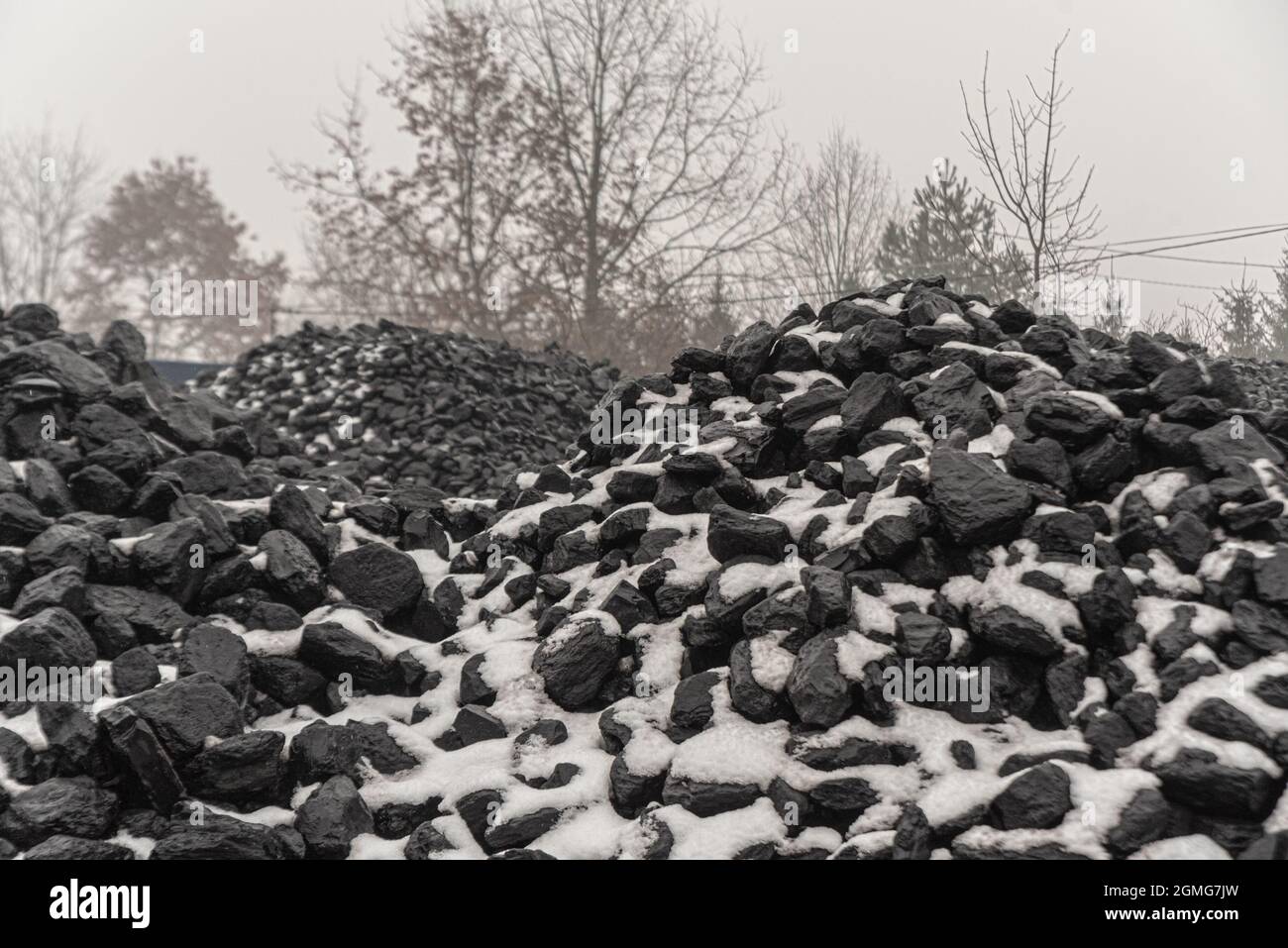 Charbon et neige. Composition du carburant en hiver. Charbon dur à vendre. Combustible pour le poêle pour le chauffage de la maison. Extraction et stockage du charbon industriel. Banque D'Images
