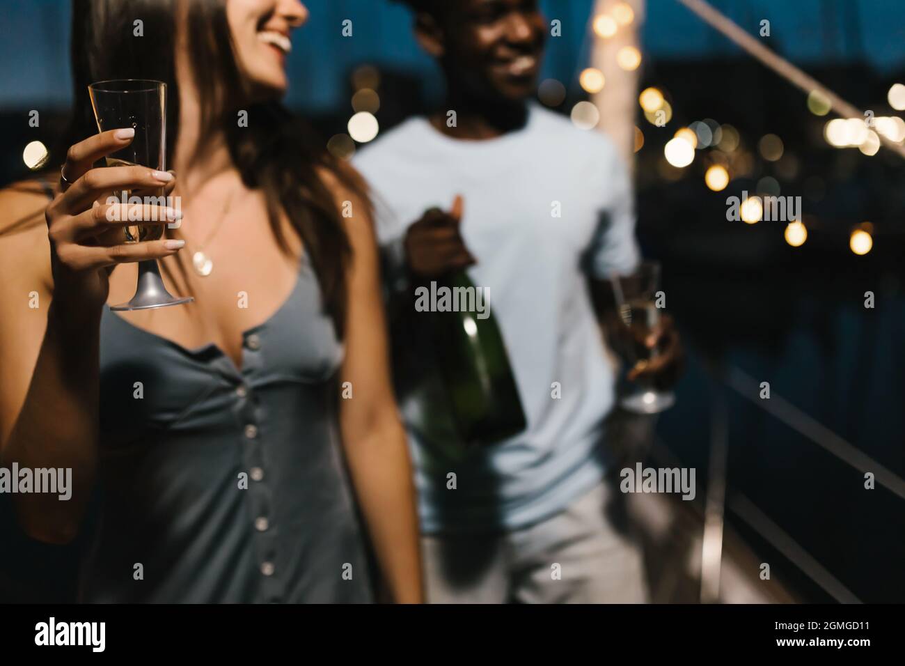 Jeune couple qui fait la fête et danse tout en buvant du champagne et en célébrant Banque D'Images