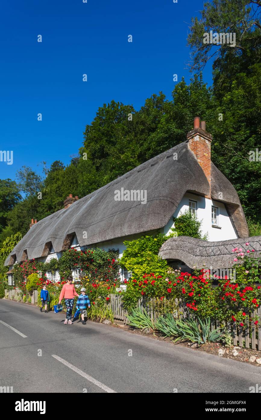 Angleterre, Hampshire, Test Valley, Wherwell, maison de campagne traditionnelle de chaume et route vide Banque D'Images