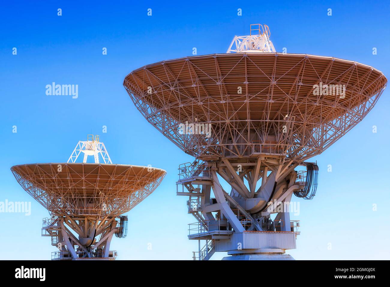 Plats principaux de deux antennes scientifiques complexes - partie du réseau radiotélescope dans la ville de Narrabri en Australie, contre ciel bleu clair. Banque D'Images