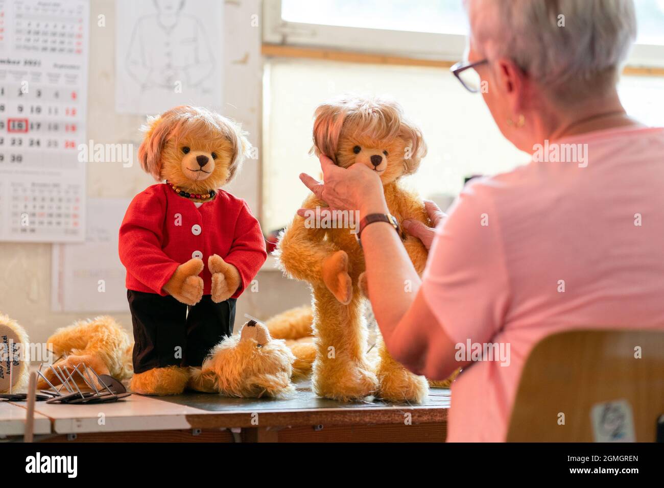 Coburg, Allemagne. 16 septembre 2021. L'ouvrier qualifié de jouet Ina  Kniewe coupe les cheveux de la peluche Merkel. L'usine de teddy Hermann de  Coburg a bourré des ours dans sa gamme qui