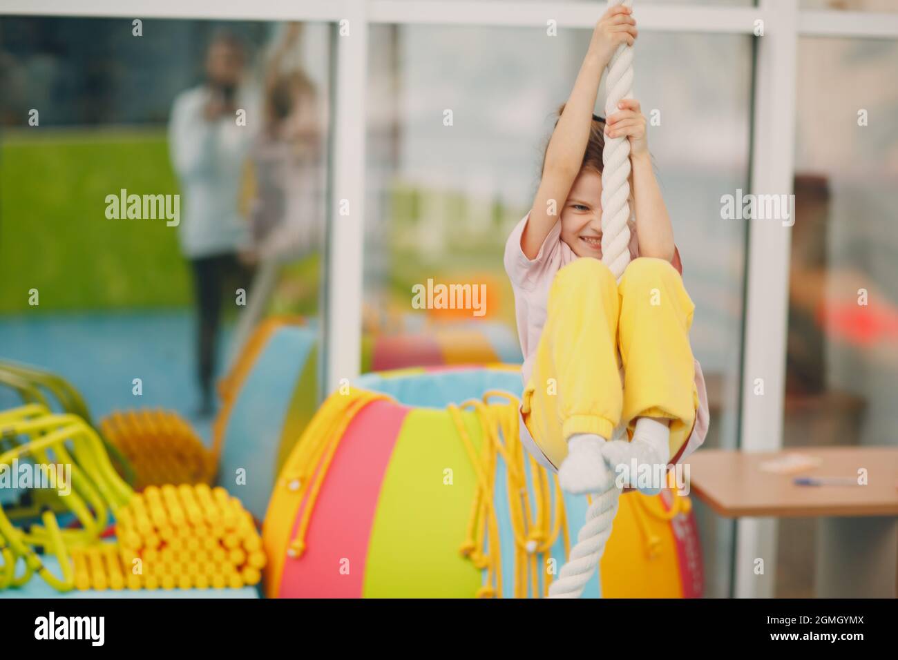 Les enfants font des exercices d'escalade en corde raide en salle de gym à la maternelle ou à l'école primaire. Concept de sport et de fitness pour enfants Banque D'Images