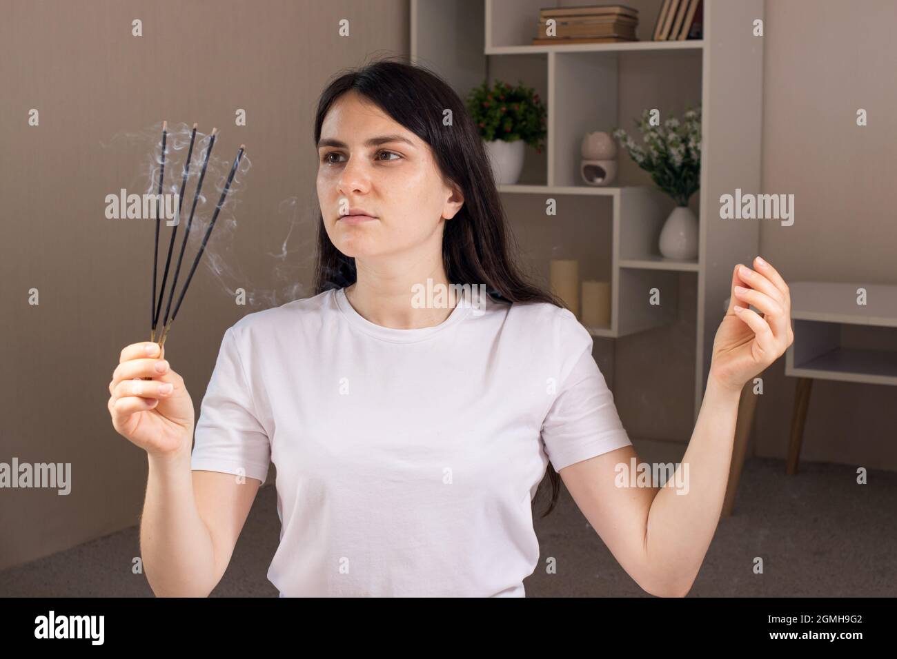 Une femme tient un ensemble de bâtons aromatiques dans ses mains. Aromathérapie, médecine alternative, traitement des névroses et des maux de tête. Banque D'Images