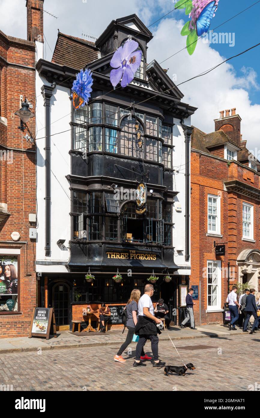 Le pub Three Pigeons sur Guildford High Street, Surrey, Royaume-Uni, avec des gens qui marchent et des buveurs assis à l'extérieur lors d'une journée ensoleillée Banque D'Images