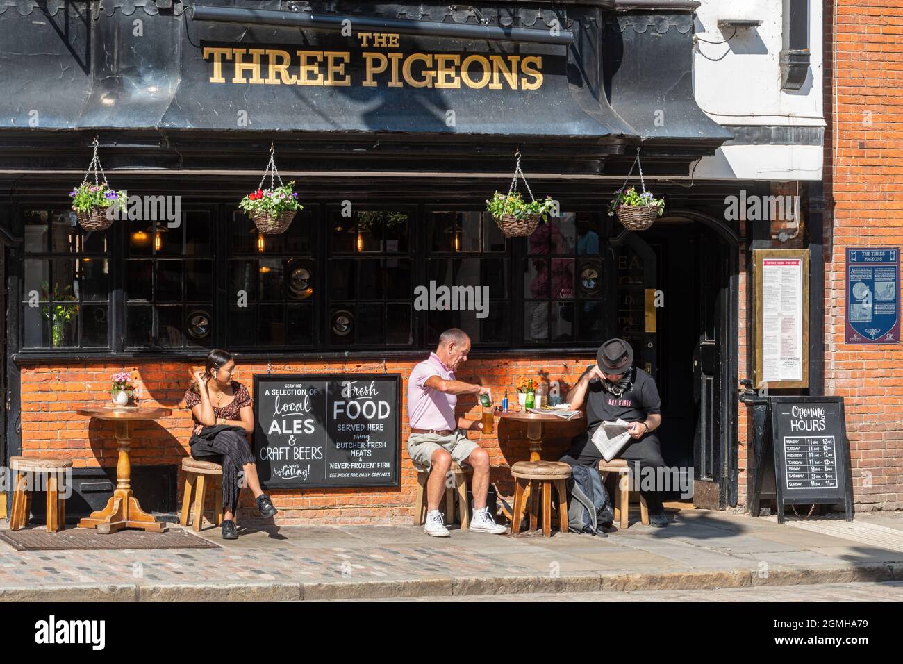 Le pub Three Pigeons, situé sur la Guildford High Street, Surrey, Royaume-Uni, accueille des personnes assises autour d'un verre lors d'une journée ensoleillée Banque D'Images