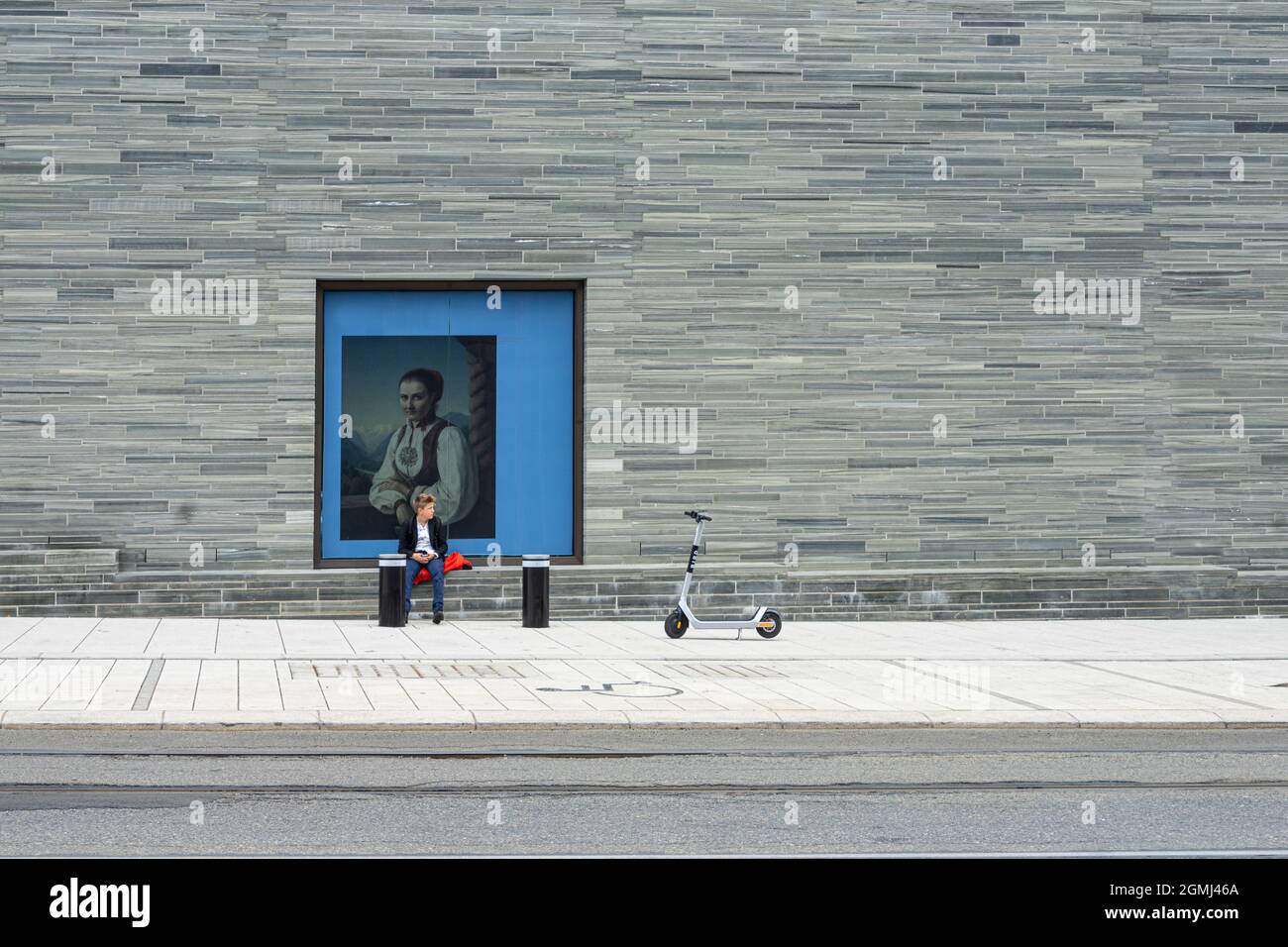 Oslo, Norvège. Septembre 2021. Un garçon assis avec une reproduction d'une peinture derrière lui sur un mur périmétrique du Musée national d'art dans Th Banque D'Images