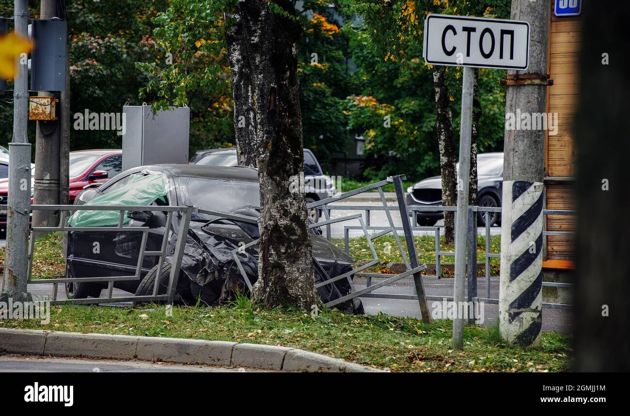 la voiture s'est écrasée dans une clôture de bord de route et a été gravement endommagée à côté d'un arbre Banque D'Images