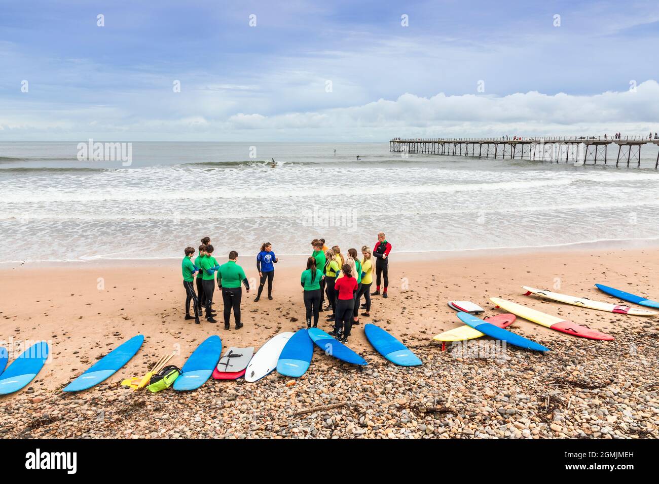 École de surf avec instructeur, élèves et planches de surf sur la plage à Saltburn by the Sea, Redcar et Cleveland District, North Yorkshire, Angleterre, Banque D'Images