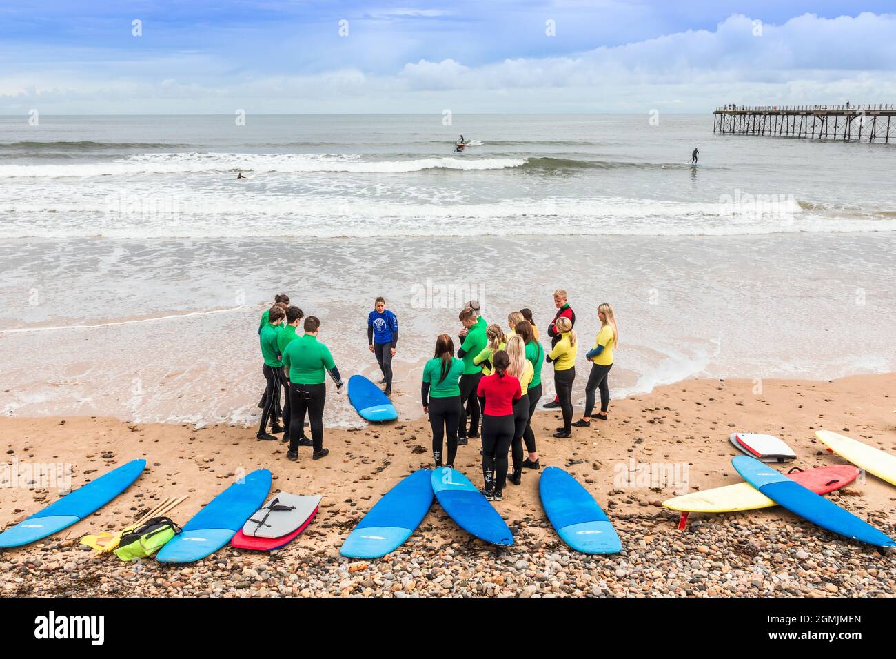 École de surf avec instructeur, élèves et planches de surf sur la plage à Saltburn by the Sea, Redcar et Cleveland District, North Yorkshire, Angleterre, Banque D'Images