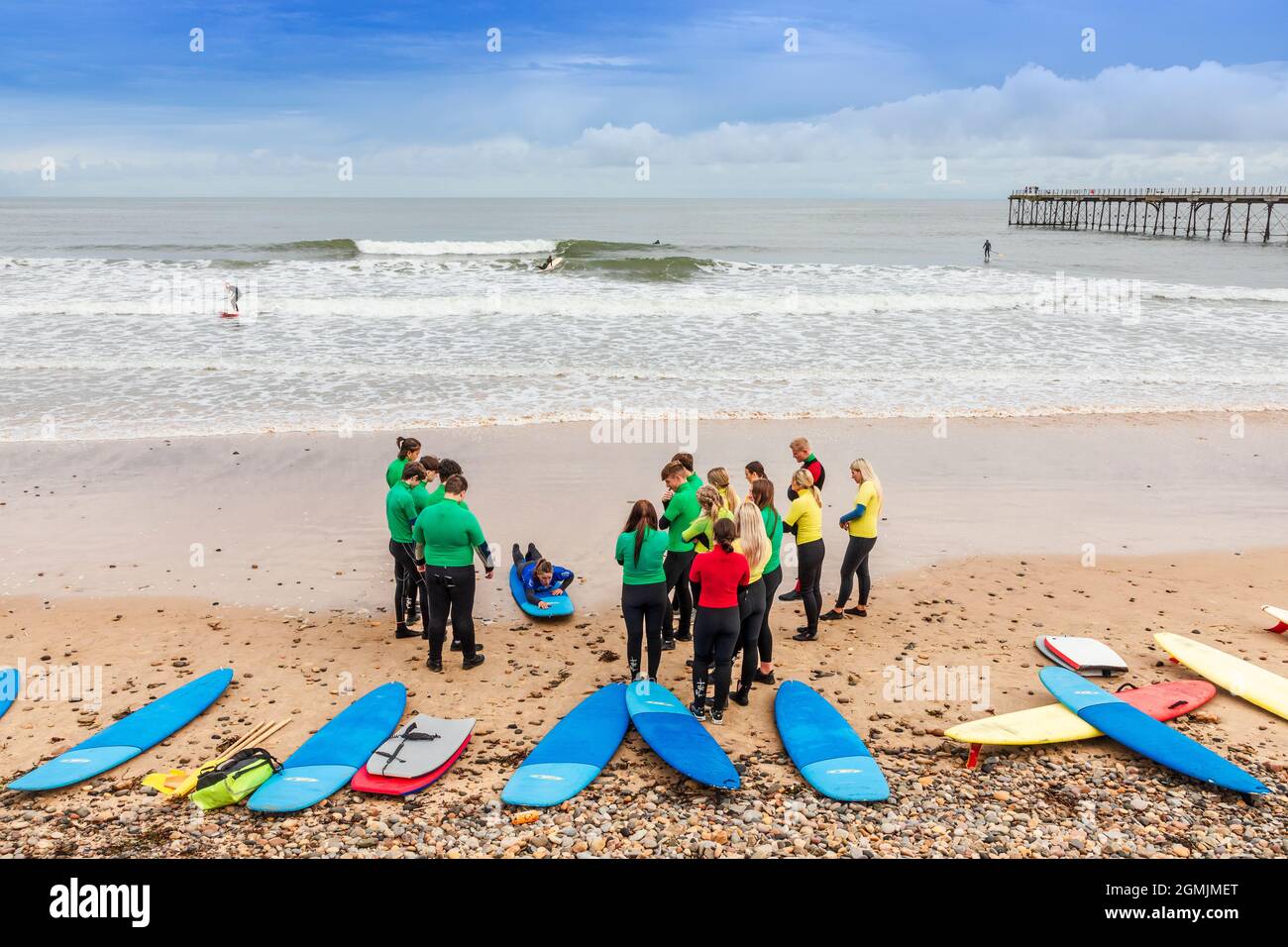 École de surf avec instructeur, élèves et planches de surf sur la plage à Saltburn by the Sea, Redcar et Cleveland District, North Yorkshire, Angleterre, Banque D'Images