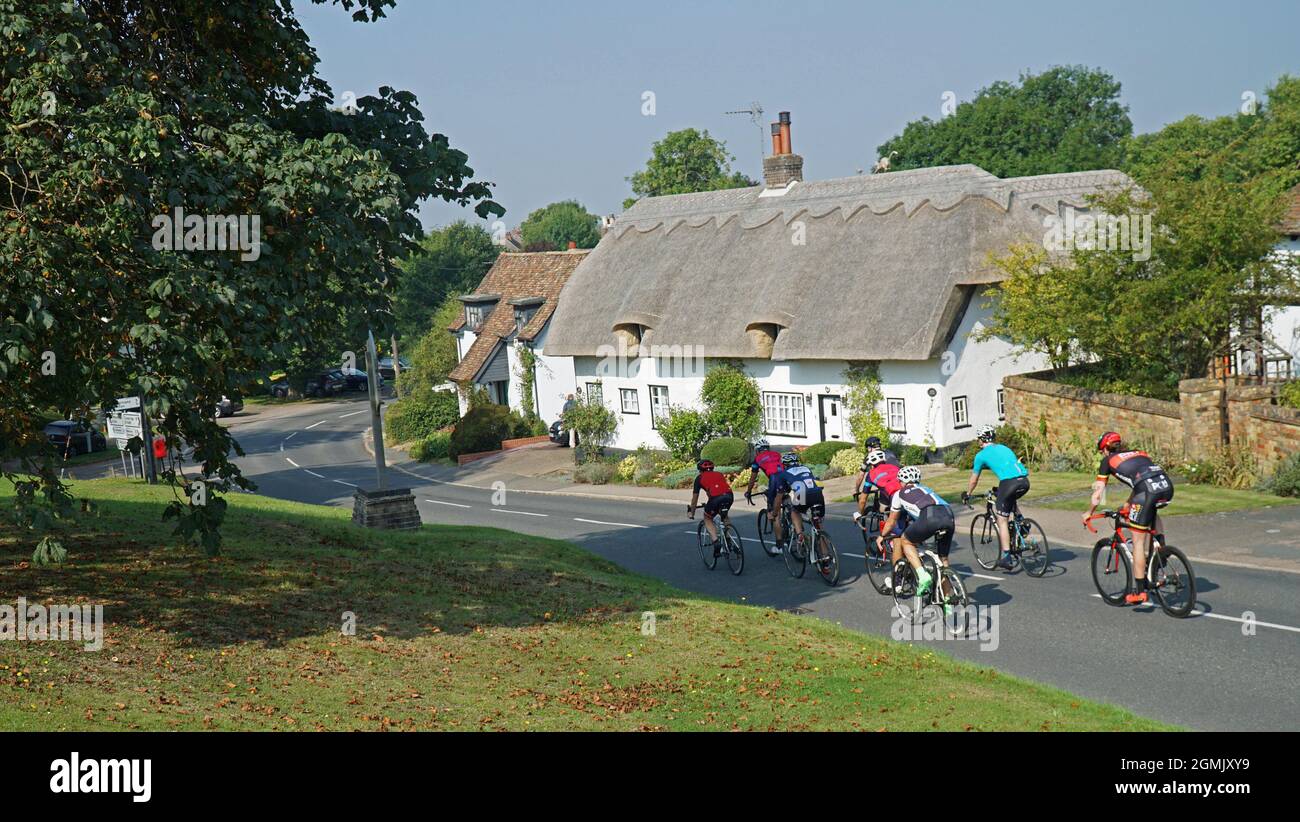 Cyclistes qui traversent le village de Cambridgeshire d'Abbotsley. Banque D'Images