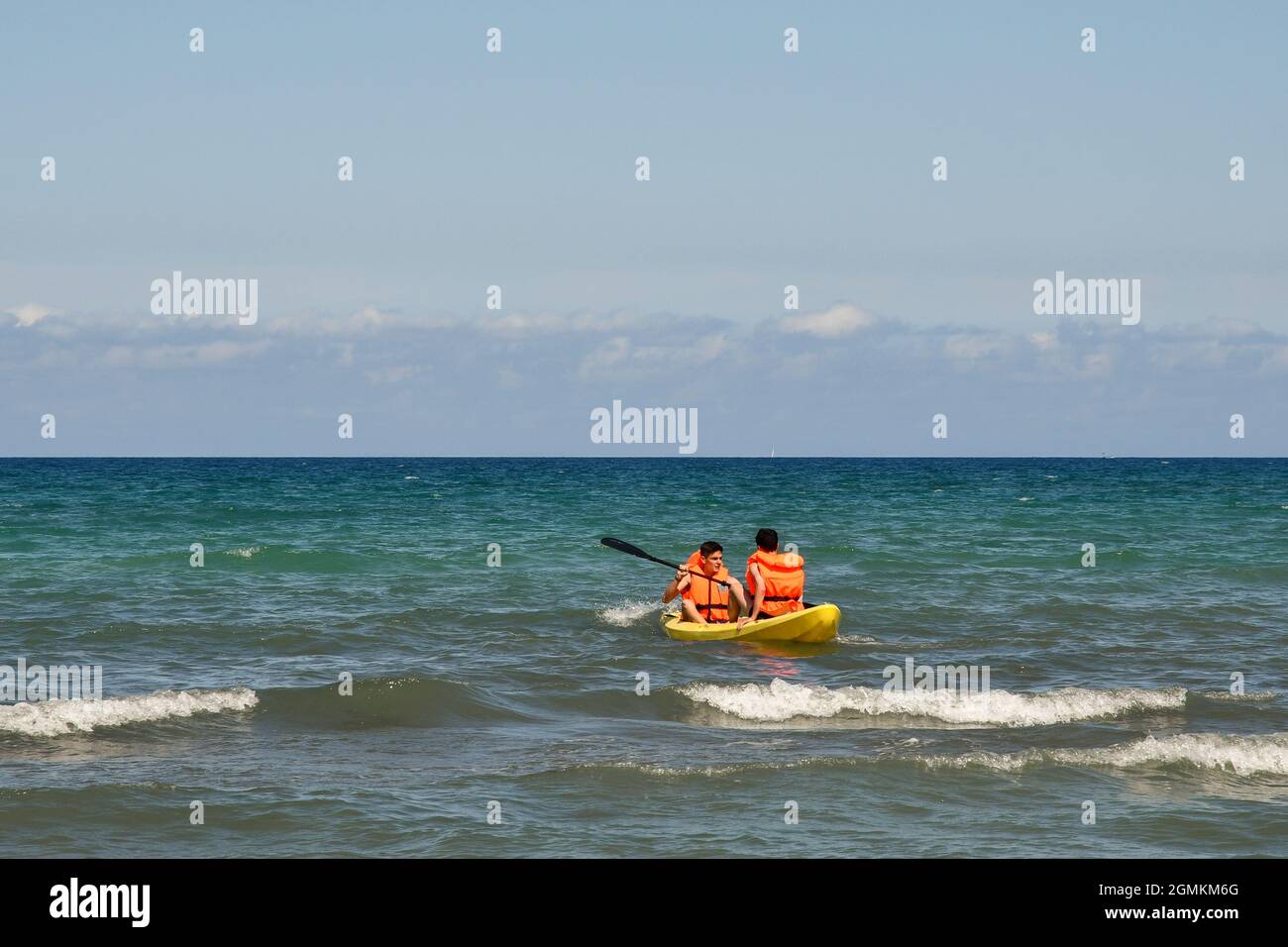 Deux gars avec des gilets de sauvetage canoë sur la mer dans une journée ensoleillée d'été avec ciel bleu clair, San Vincenzo, Livourne, Toscane, Italie Banque D'Images