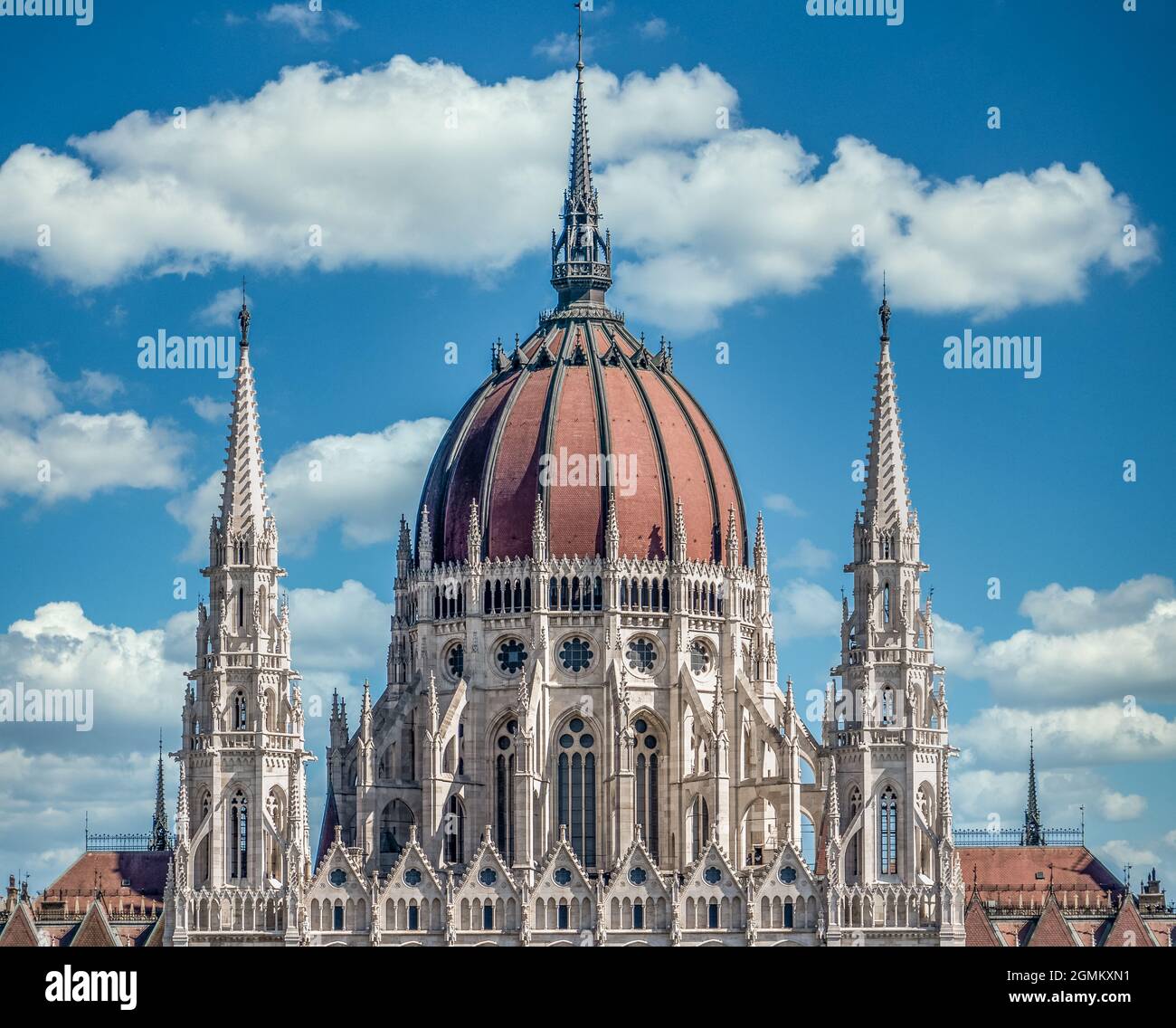 Vue d'été du Parlement hongrois construit dans le style néo-gothique le long du Danube avec une parfaite symétrie avec ciel bleu nuageux Banque D'Images