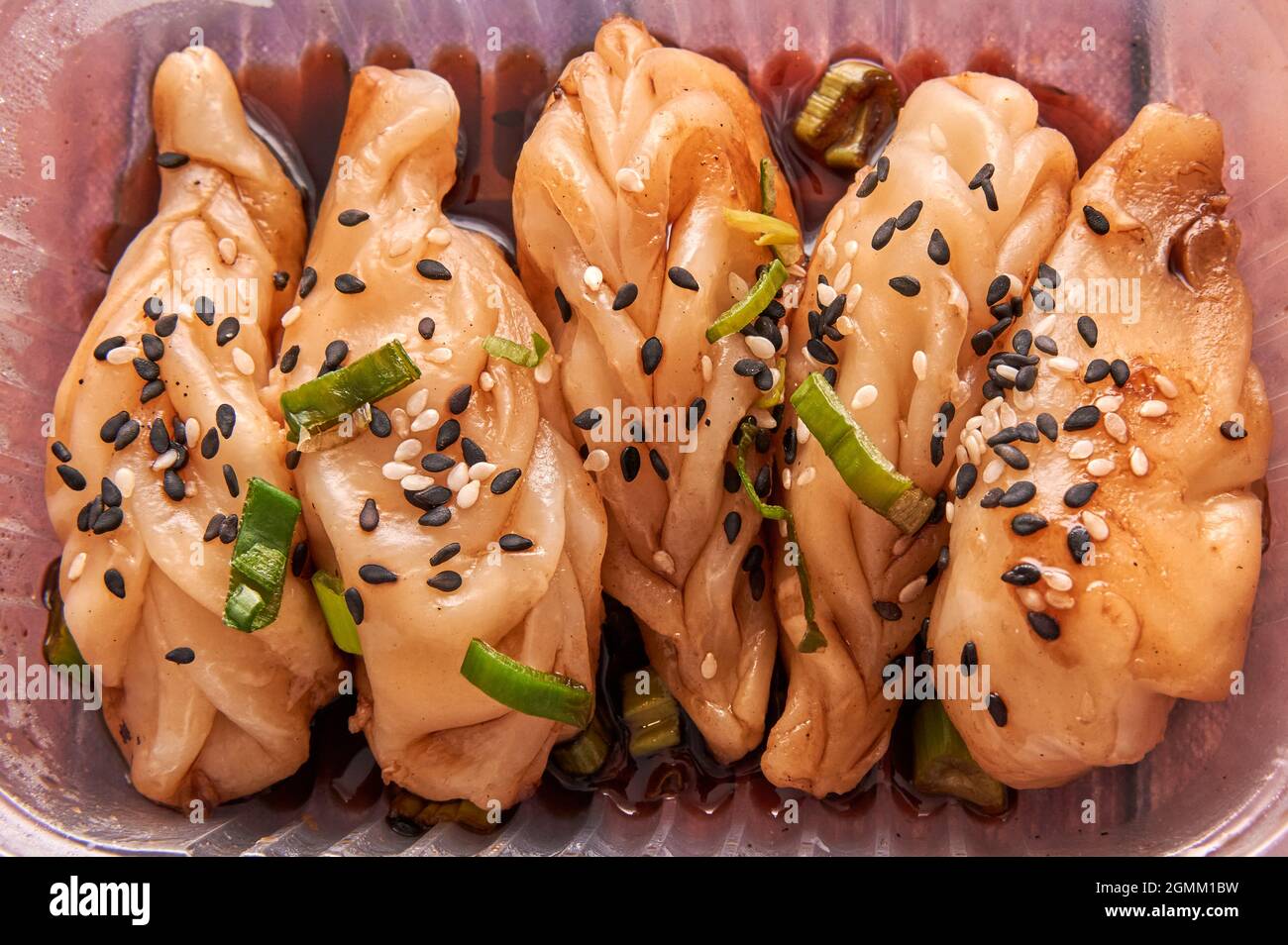 cinq gyozas. boulettes chinoises cuites à la vapeur décorées de graines sur le dessus et de sauce soja. Cuisine asiatique traditionnelle. Horizontale. Vue aérienne Banque D'Images