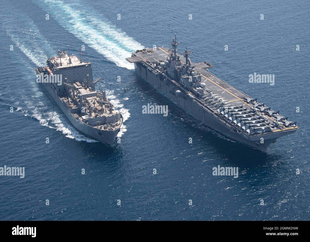 GOLFE PERSIQUE (18 septembre 2021) le navire de cargaison sèche et de munitions USNS Wally Schirra (T-AKE 8), à gauche, effectue un réapprovisionnement en mer avec le navire d'assaut amphibie Essex (USS LHD 2), à droite, le 18 septembre. Essex et la 11e unité expéditionnaire maritime sont déployés dans la zone d'opérations de la 5e flotte des États-Unis afin d'assurer la stabilité et la sécurité maritimes dans la région centrale, reliant la Méditerranée et le Pacifique à travers l'ouest de l'océan Indien et trois points d'étranglement stratégiques. (É.-U. Photo de la marine par le spécialiste des communications de masse de 2e classe Wesley Richardson) Banque D'Images