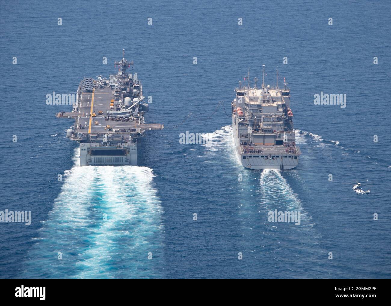 GOLFE PERSIQUE (18 septembre 2021) le navire de cargaison sèche et de munitions USNS Wally Schirra (T-AKE 8), à droite, effectue un réapprovisionnement en mer (RAS) avec le navire d'assaut amphibie USS Essex (LHD 2), à gauche, le 18 septembre. Essex et la 11e unité expéditionnaire maritime sont déployés dans la zone d'opérations de la 5e flotte des États-Unis afin d'assurer la stabilité et la sécurité maritimes dans la région centrale, reliant la Méditerranée et le Pacifique à travers l'ouest de l'océan Indien et trois points d'étranglement stratégiques. (É.-U. Photo de la marine par le spécialiste des communications de masse de 2e classe Wesley Richardson) Banque D'Images