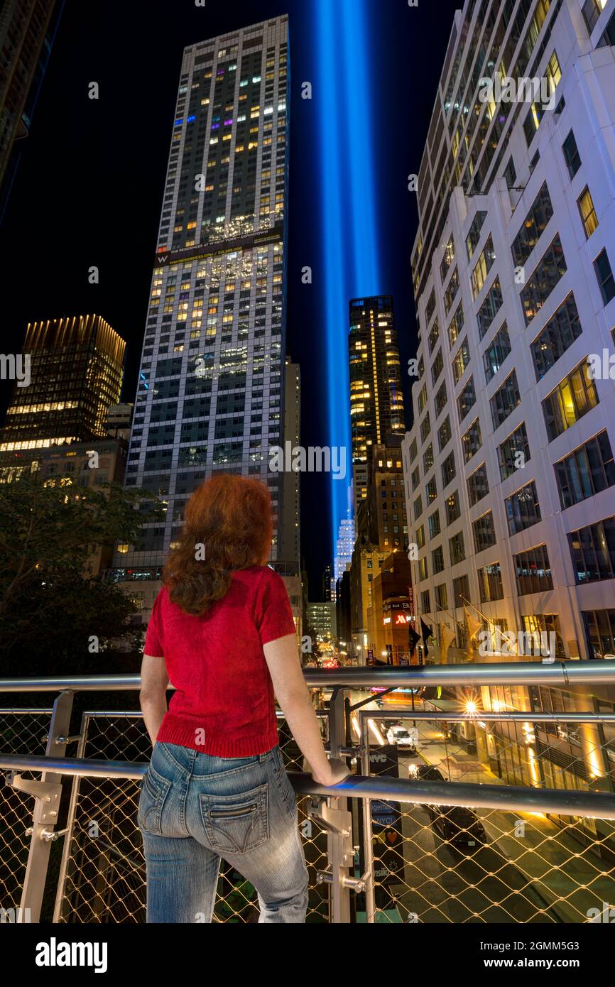 9/11 hommage à la lumière. Lower Manhattan illuminé la nuit. Femme regardant Washington Street. Vue depuis Liberty Park, Manhattan, États-Unis. Banque D'Images