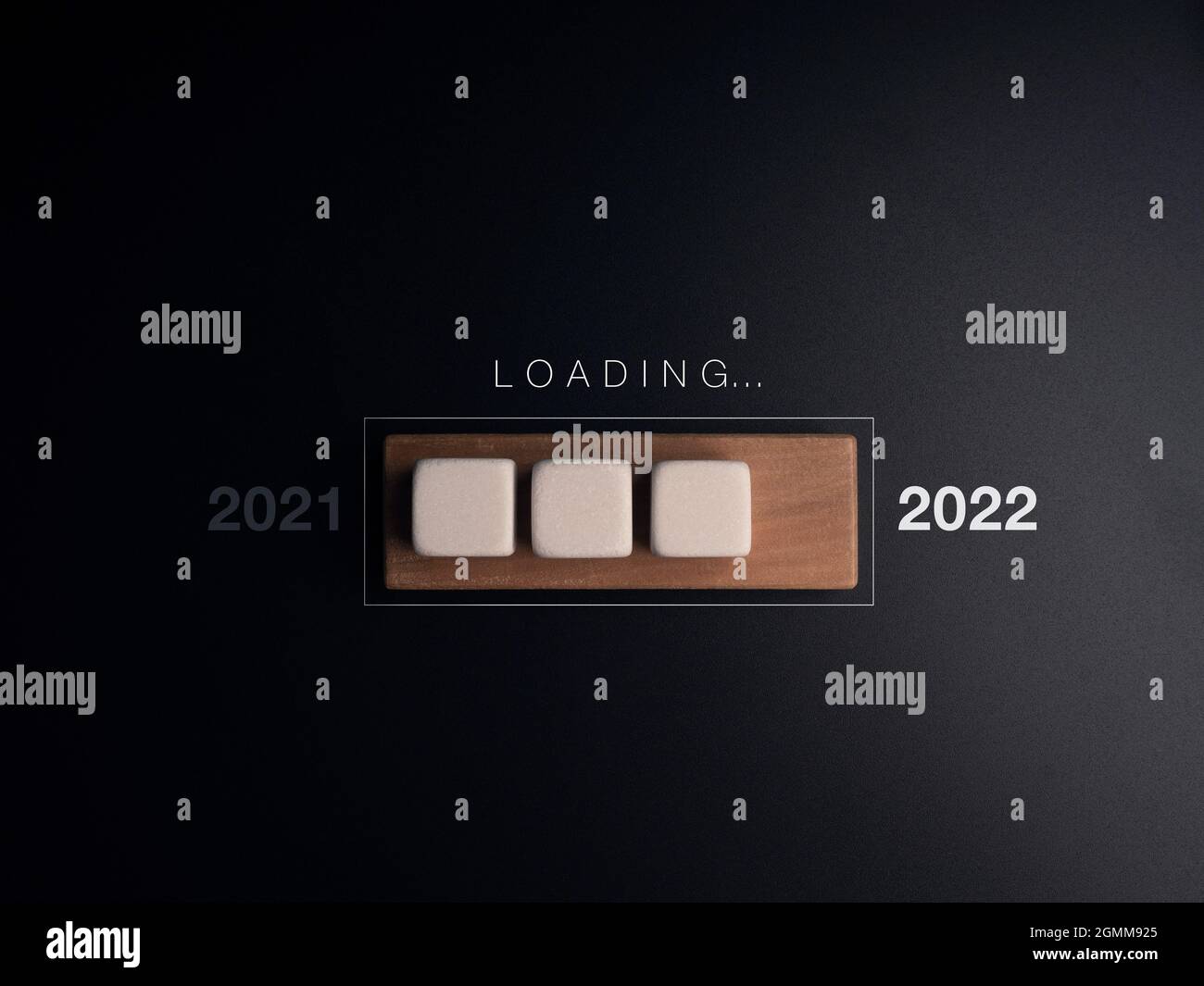 Chargement de 2021 au concept de 2022 ans. Des cubes de mot et de blanc se bloquent sur la barre de progression en bois, sur fond sombre. Il s'agit de faire des mises à jour Banque D'Images