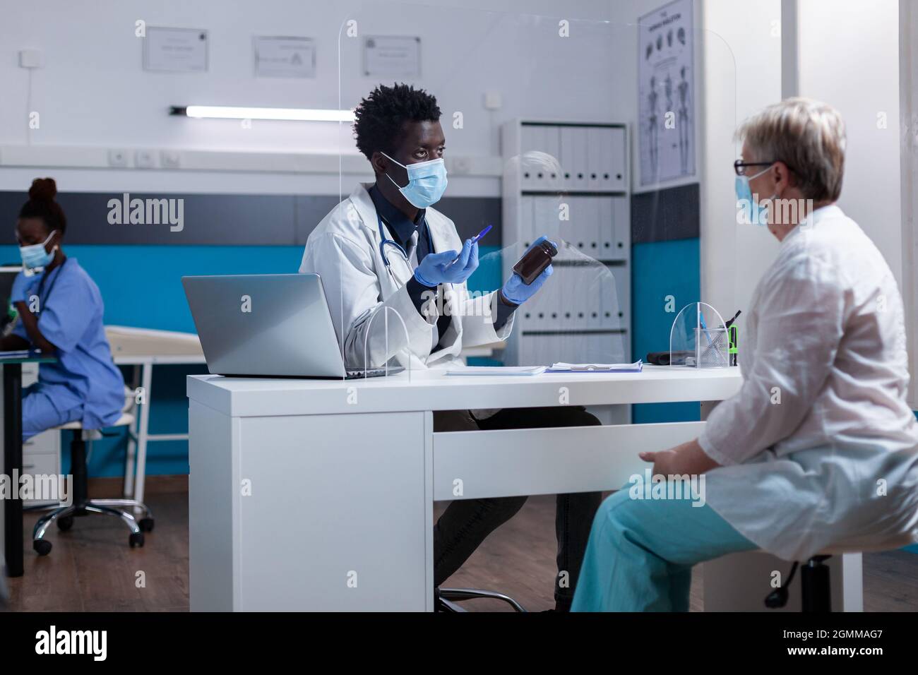 Patients âgés de race blanche qui reçoivent une bouteille de médicament pour le traitement à la clinique médicale. Médecin afro-américain donnant des conseils à une femme âgée atteinte de maladie. Personne âgée assise avec un médic noir Banque D'Images