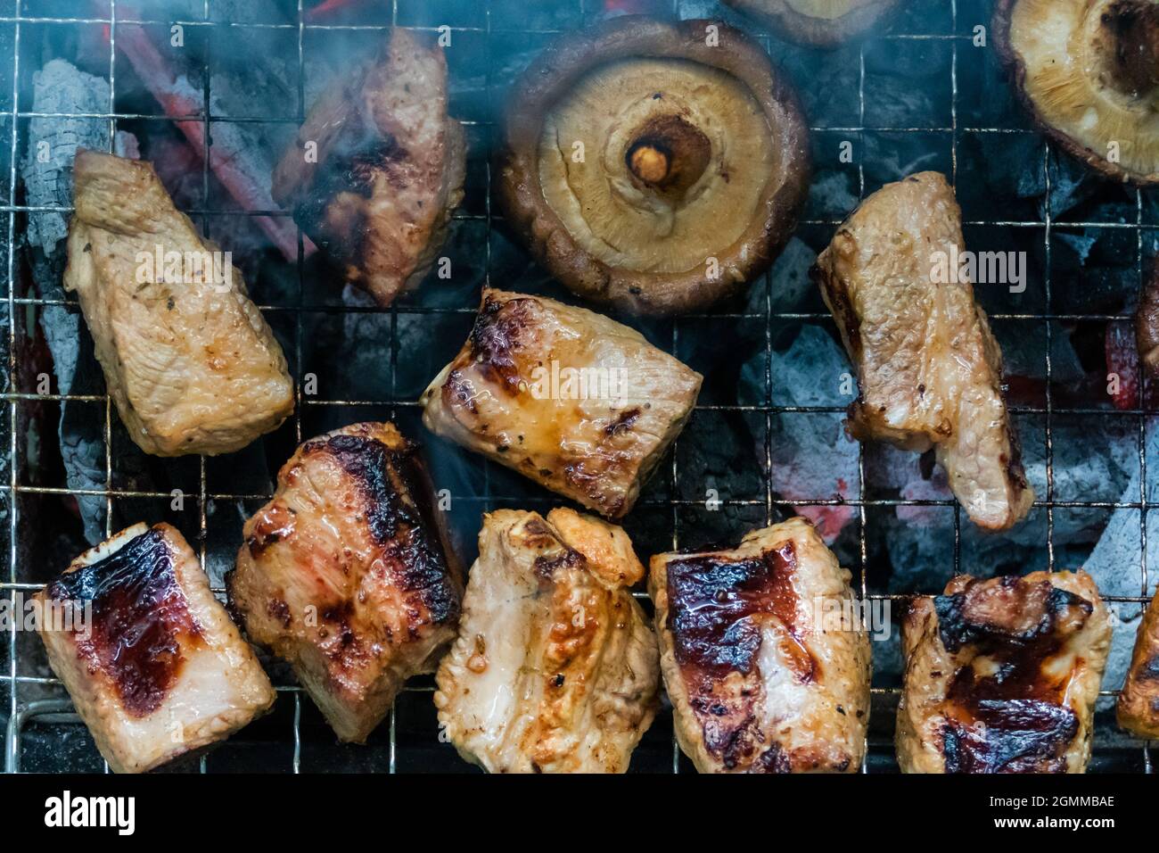 Champignons et grillades de viande sur un barbecue, vue du dessus Banque D'Images